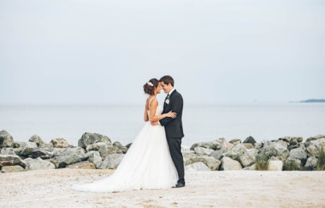newlyweds standing near beach rocks, photographed by Eivan's in Washington
