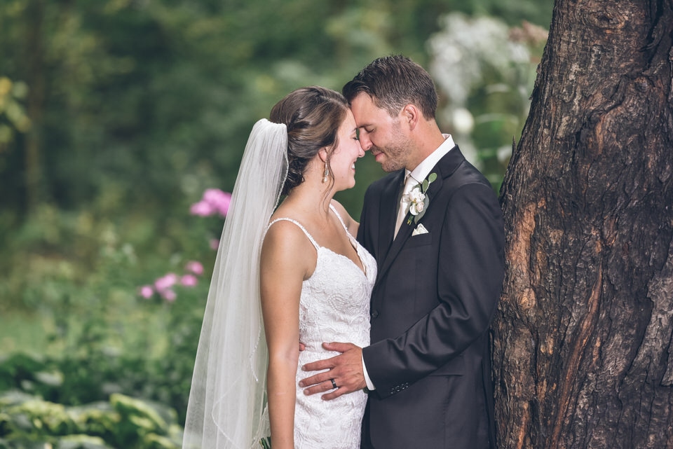 man in black suit kissing woman in white wedding dress