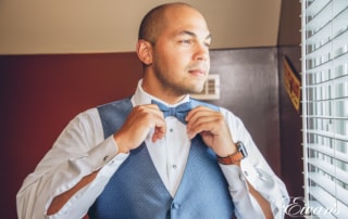 man in a suit fixing his bow tie