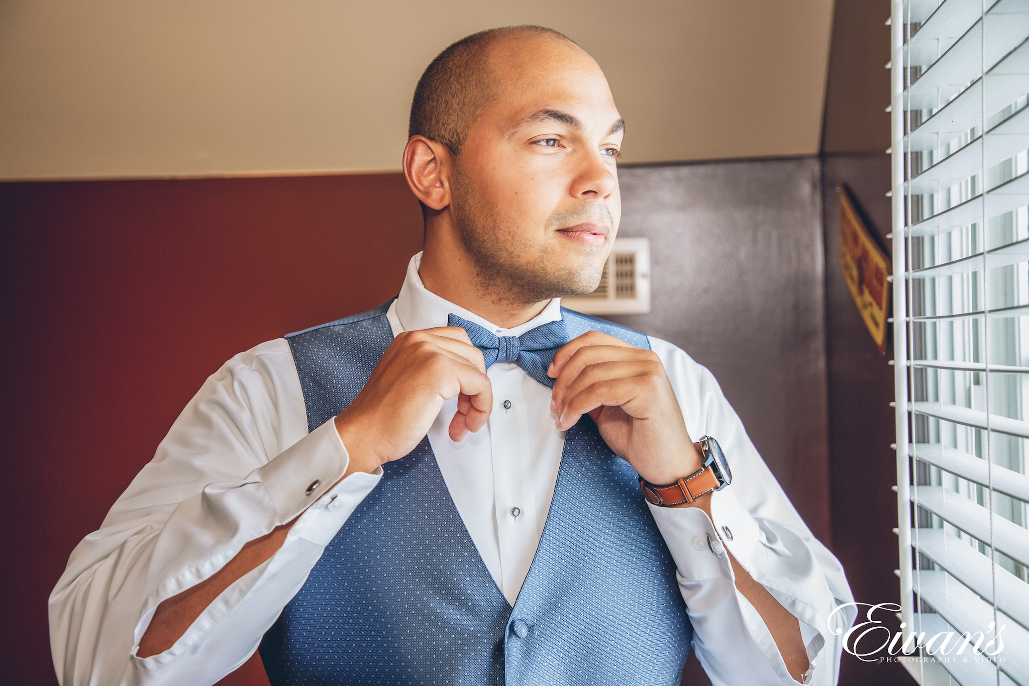 man in a suit fixing his bow tie