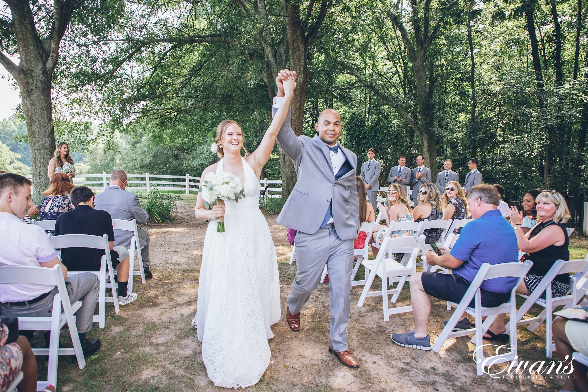 man and woman holding hands up while walking down the aisle