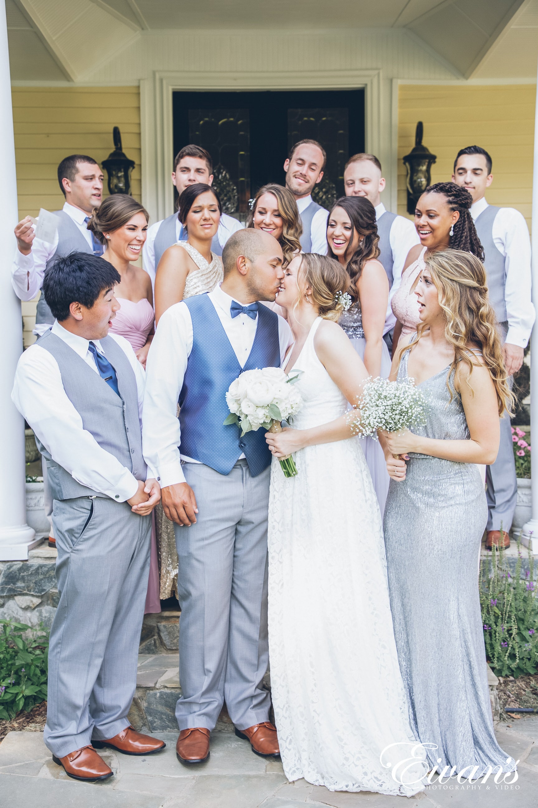 bride and groom kissing in front of bridal party