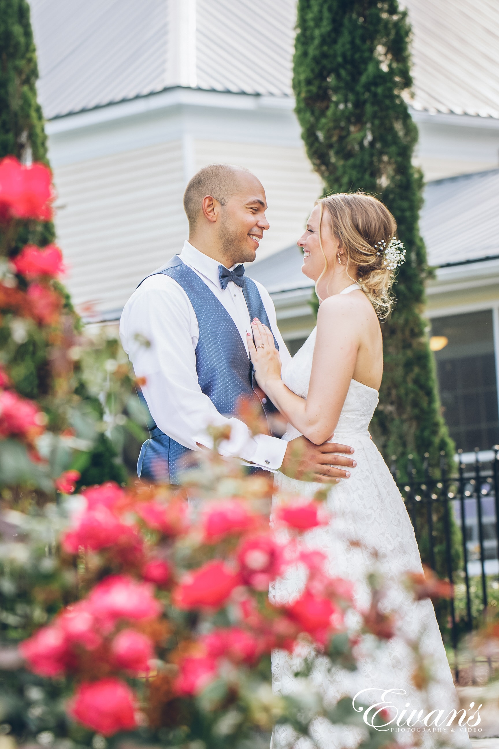 man in blue suit and woman in white dress embracing