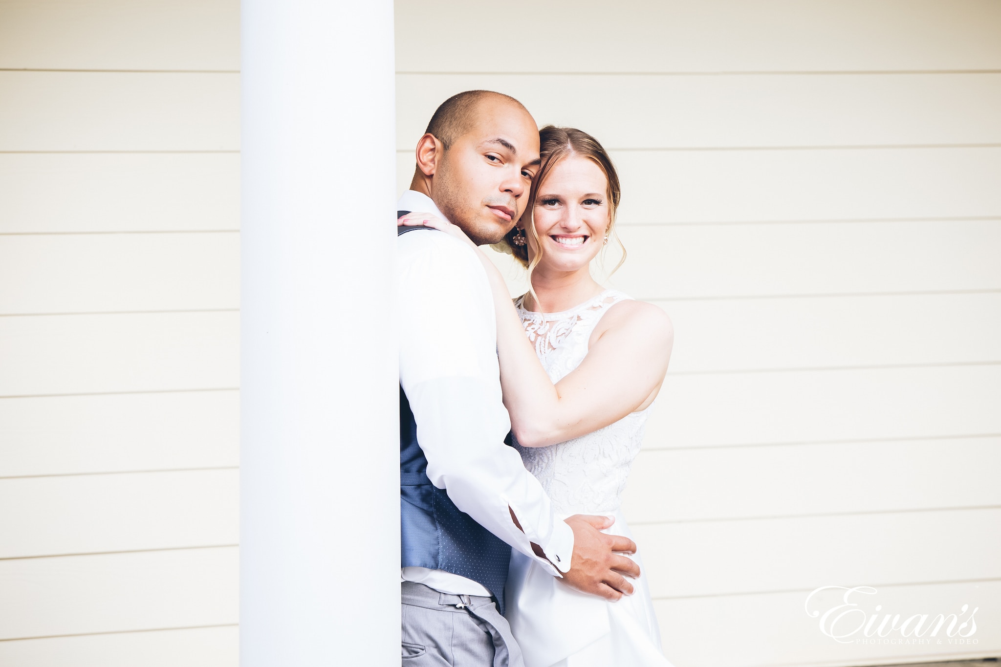 man and woman in a white dress posed in front of a porch