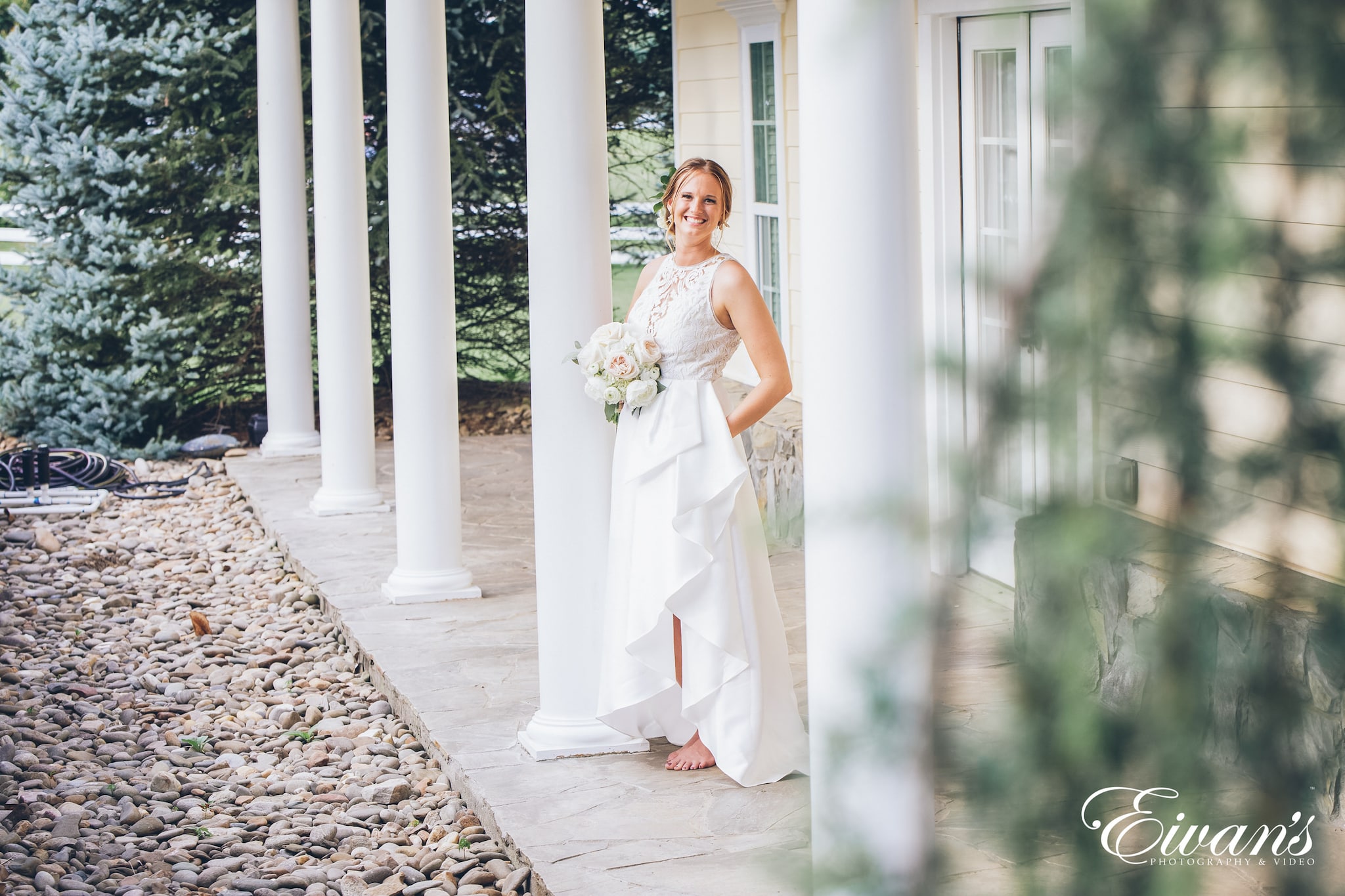 woman in a white dress posed on a porch