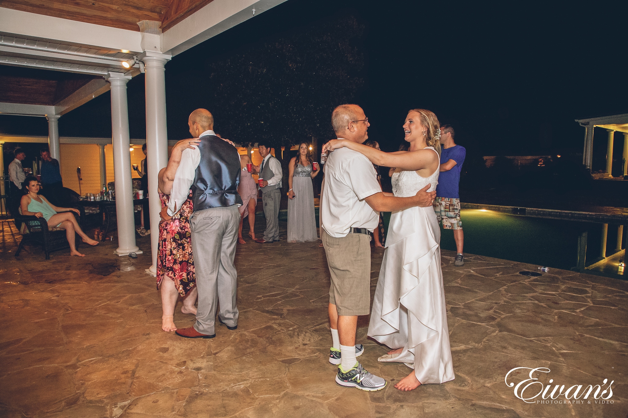 bride in a white dress dancing with her father