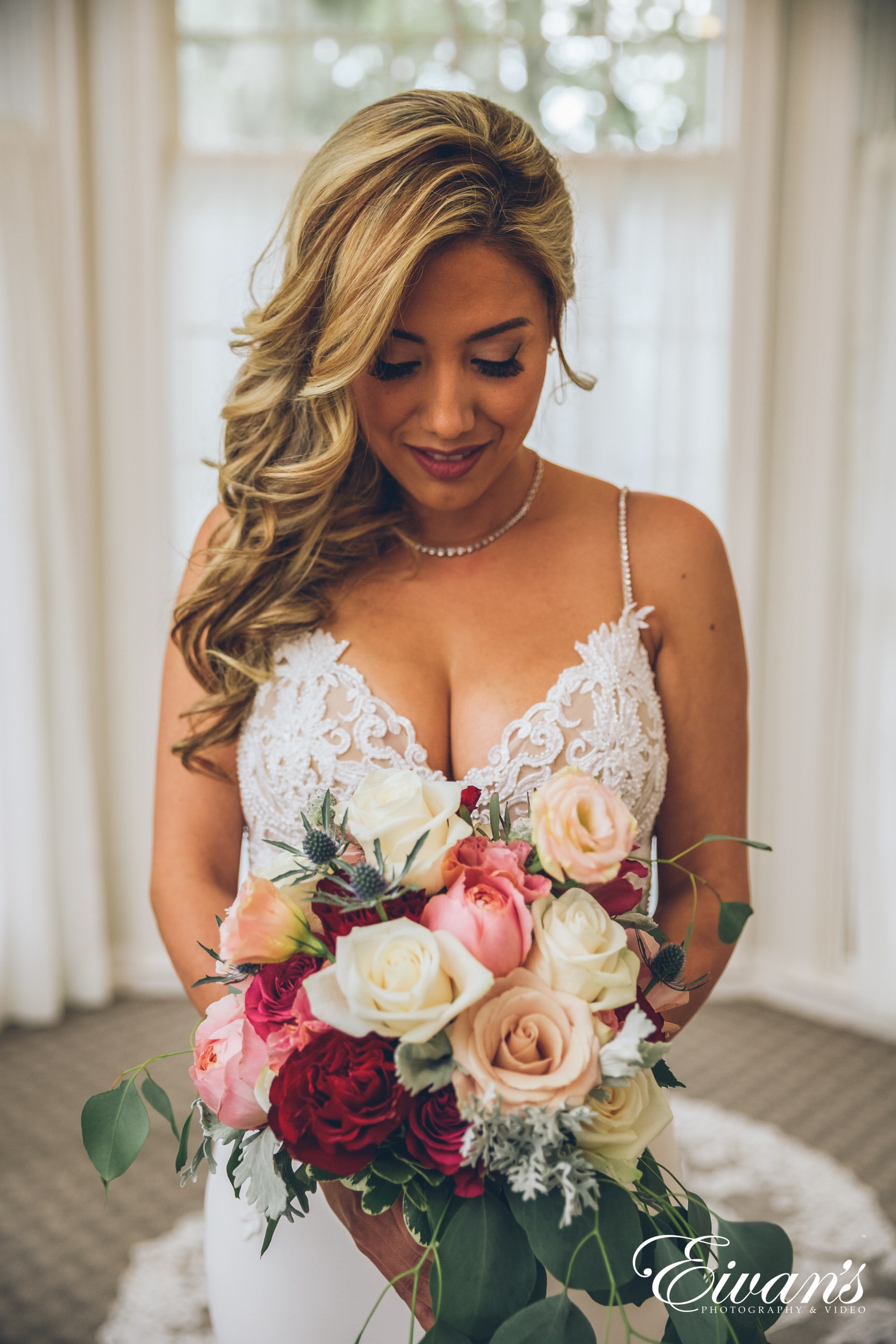 woman in white and pink floral spaghetti strap dress holding bouquet of flowers