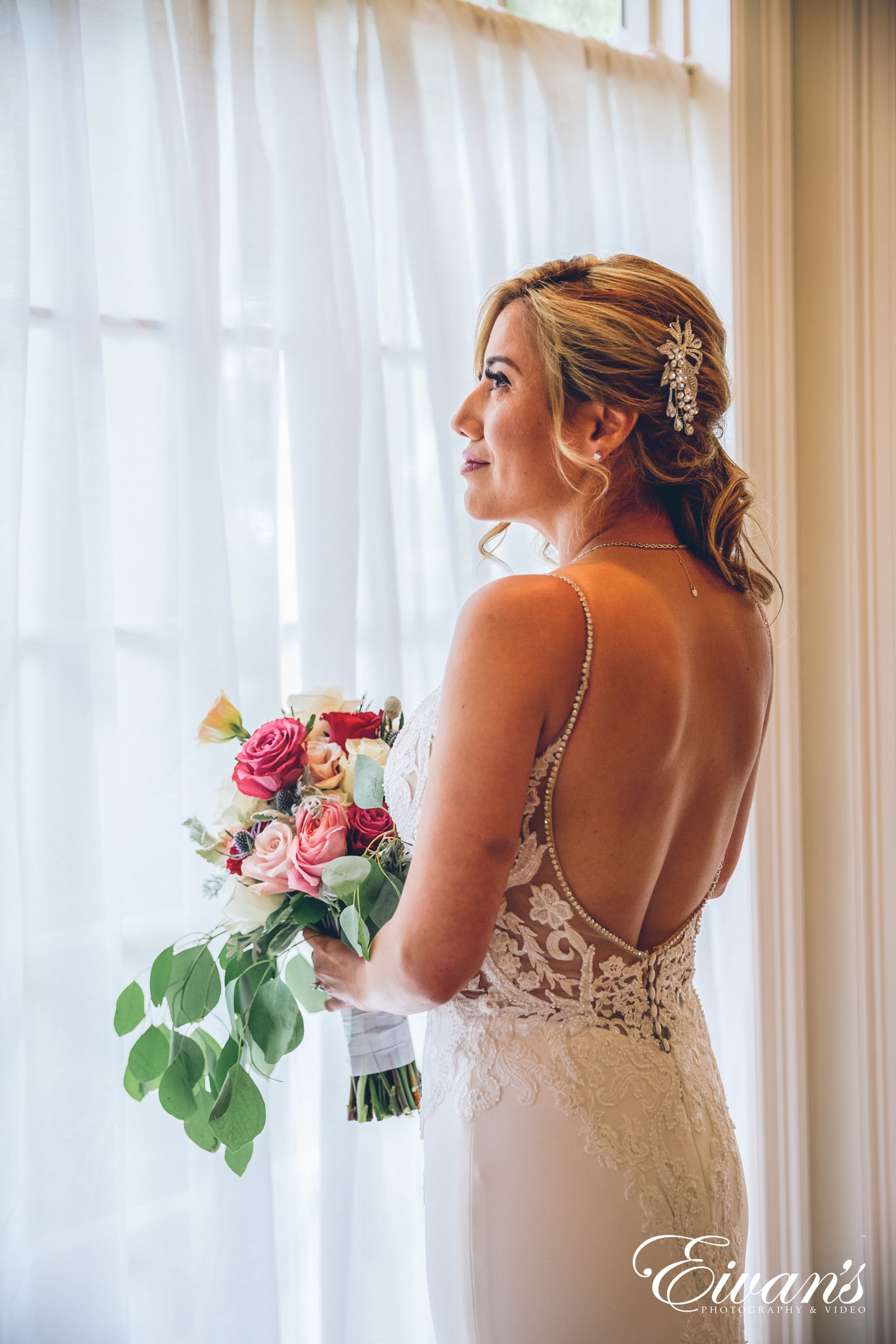 woman in white floral spaghetti strap dress holding bouquet of flowers