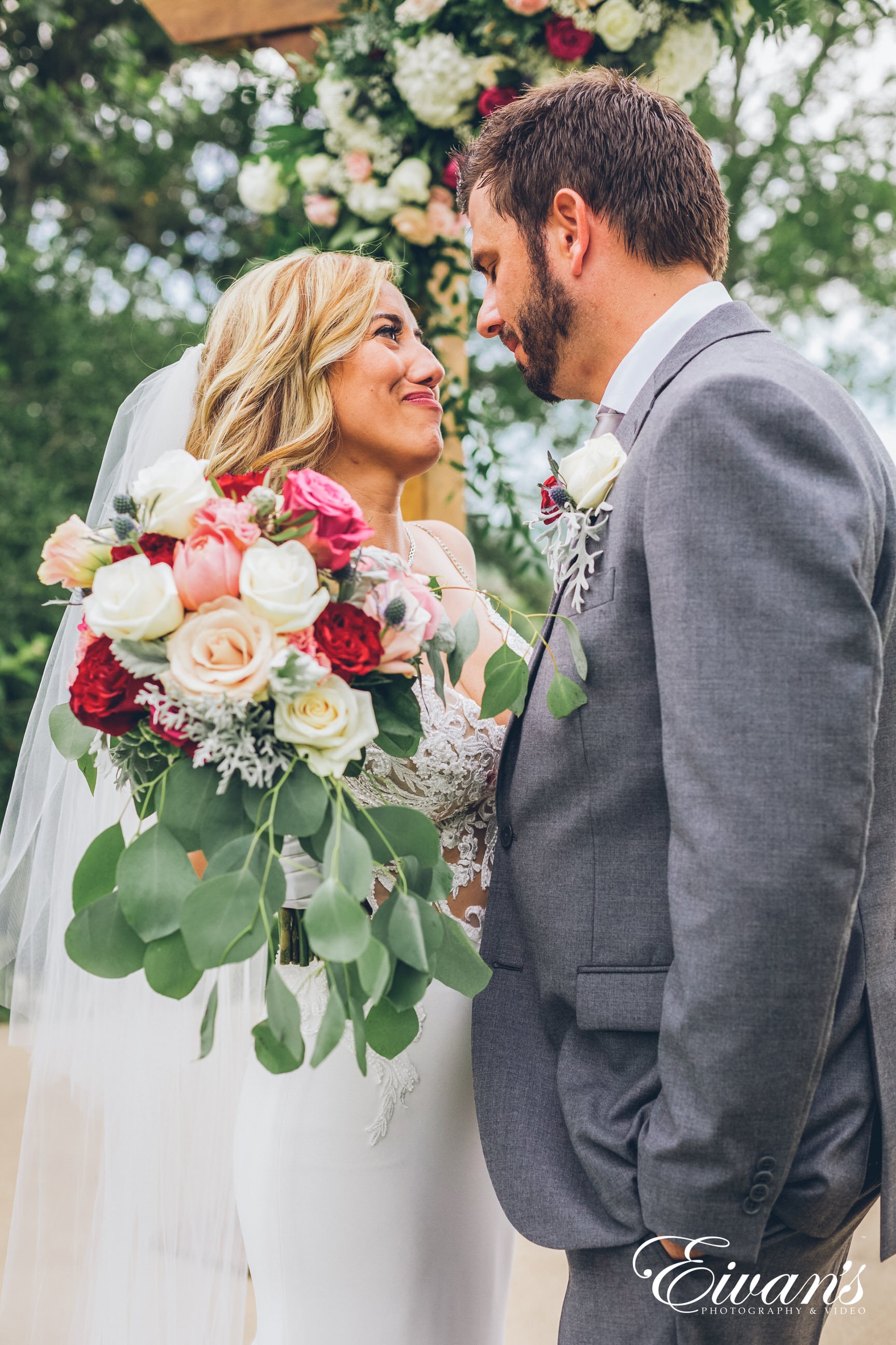 man in black suit jacket holding bouquet of flowers