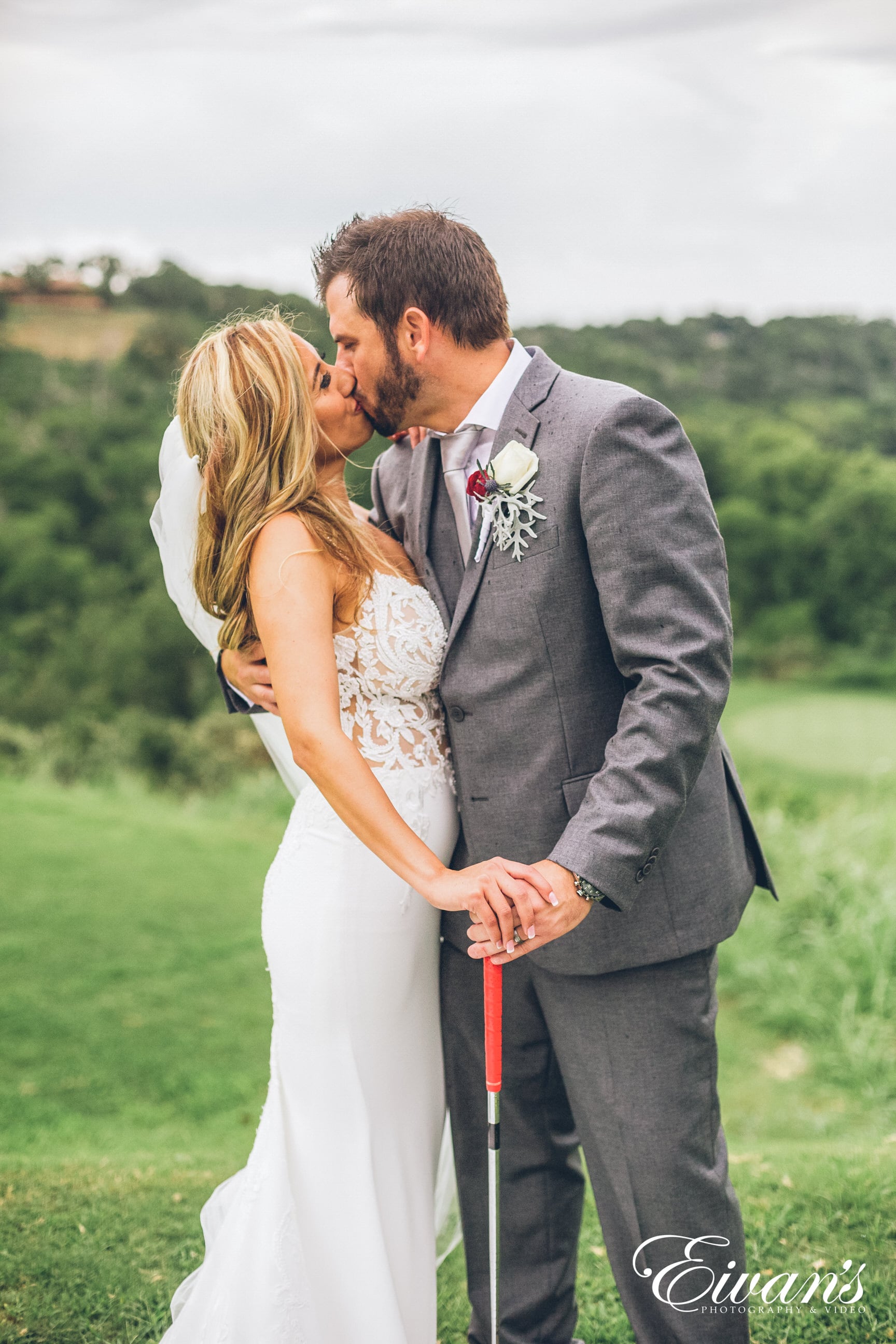 man in black suit and woman in white dress holding hands