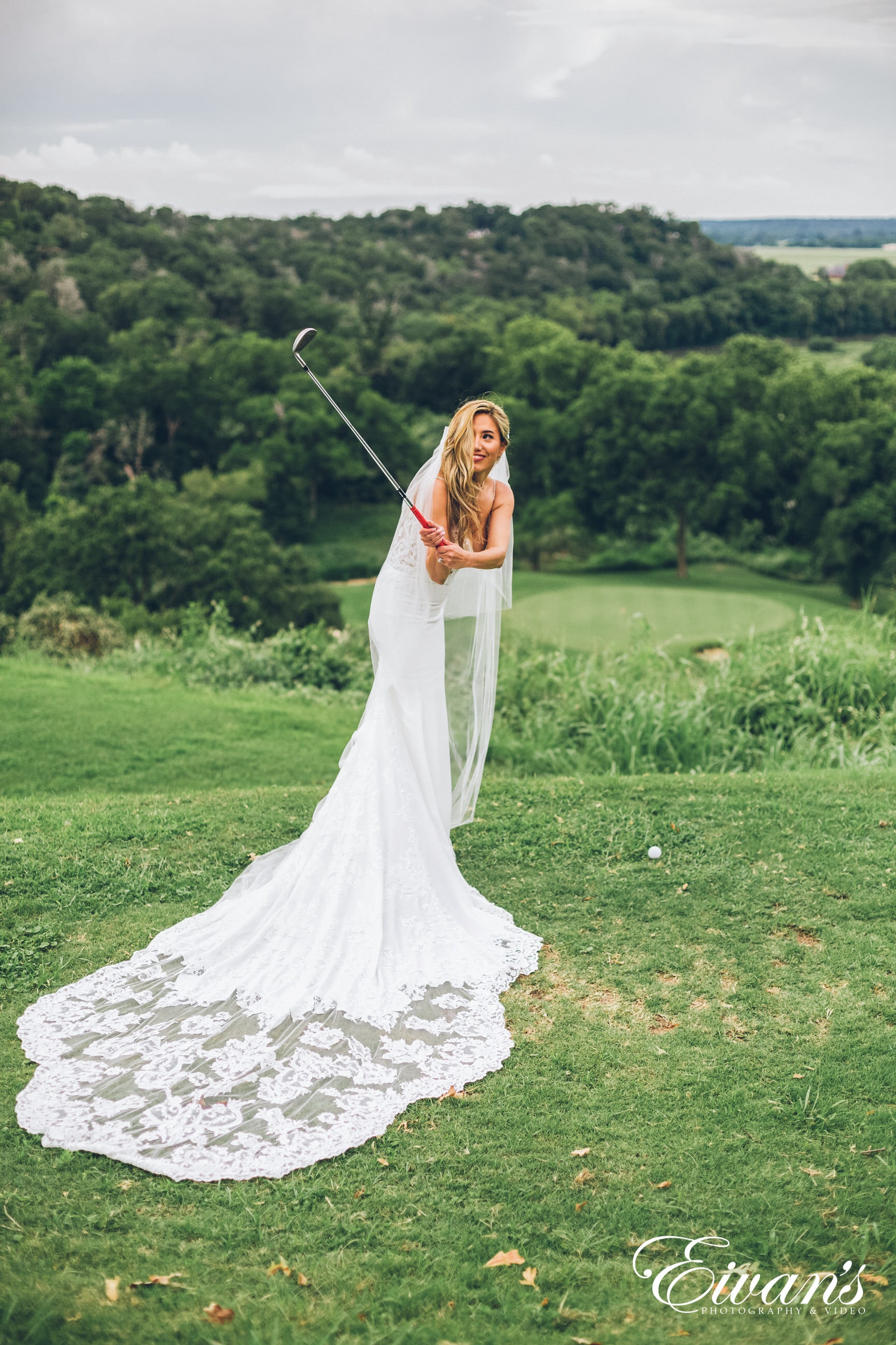 woman in white dress holding stick standing on green grass field during daytime