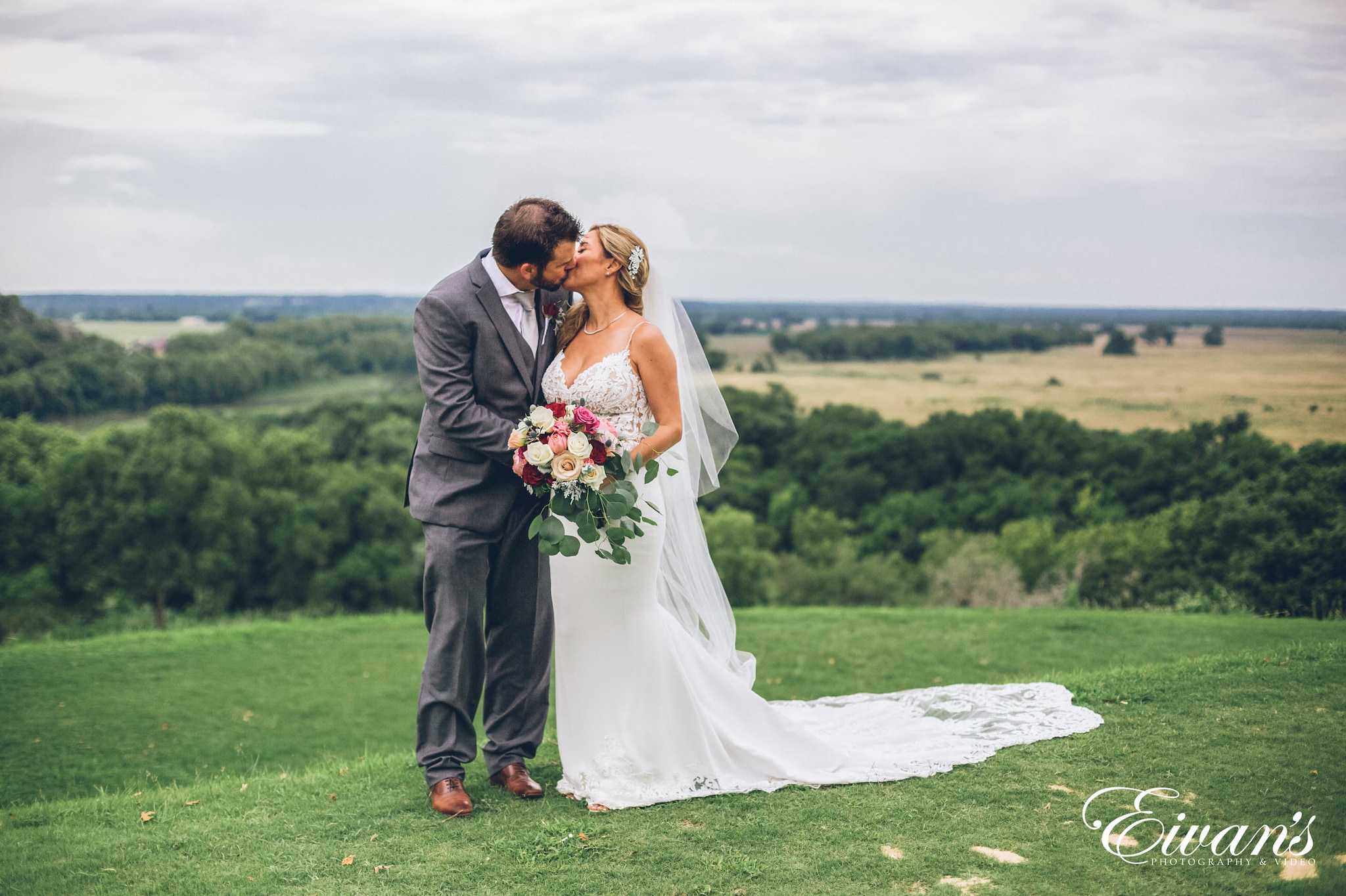 man and woman kissing on green grass field during daytime