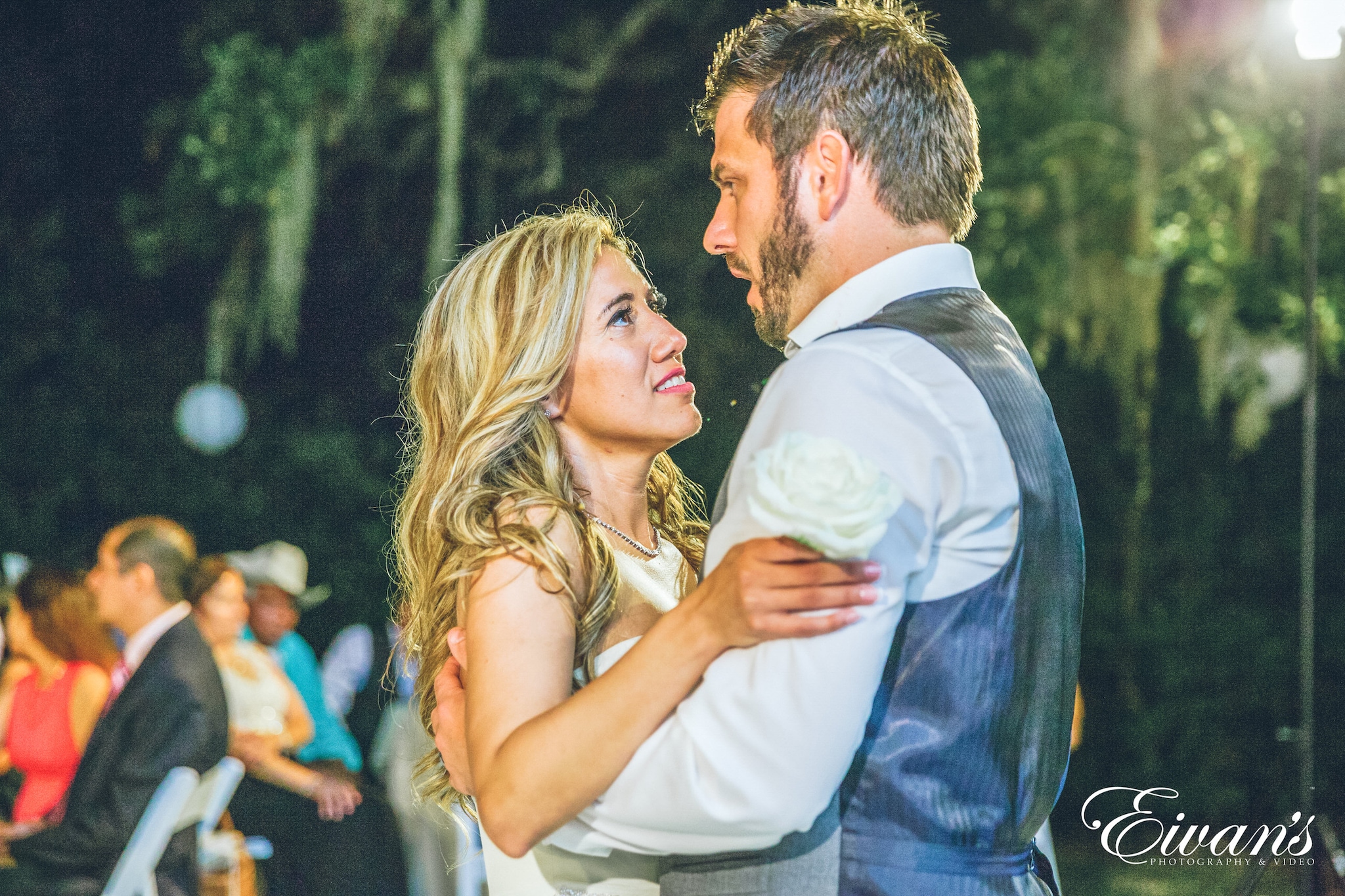 man in blue suit kissing woman in white sleeveless dress