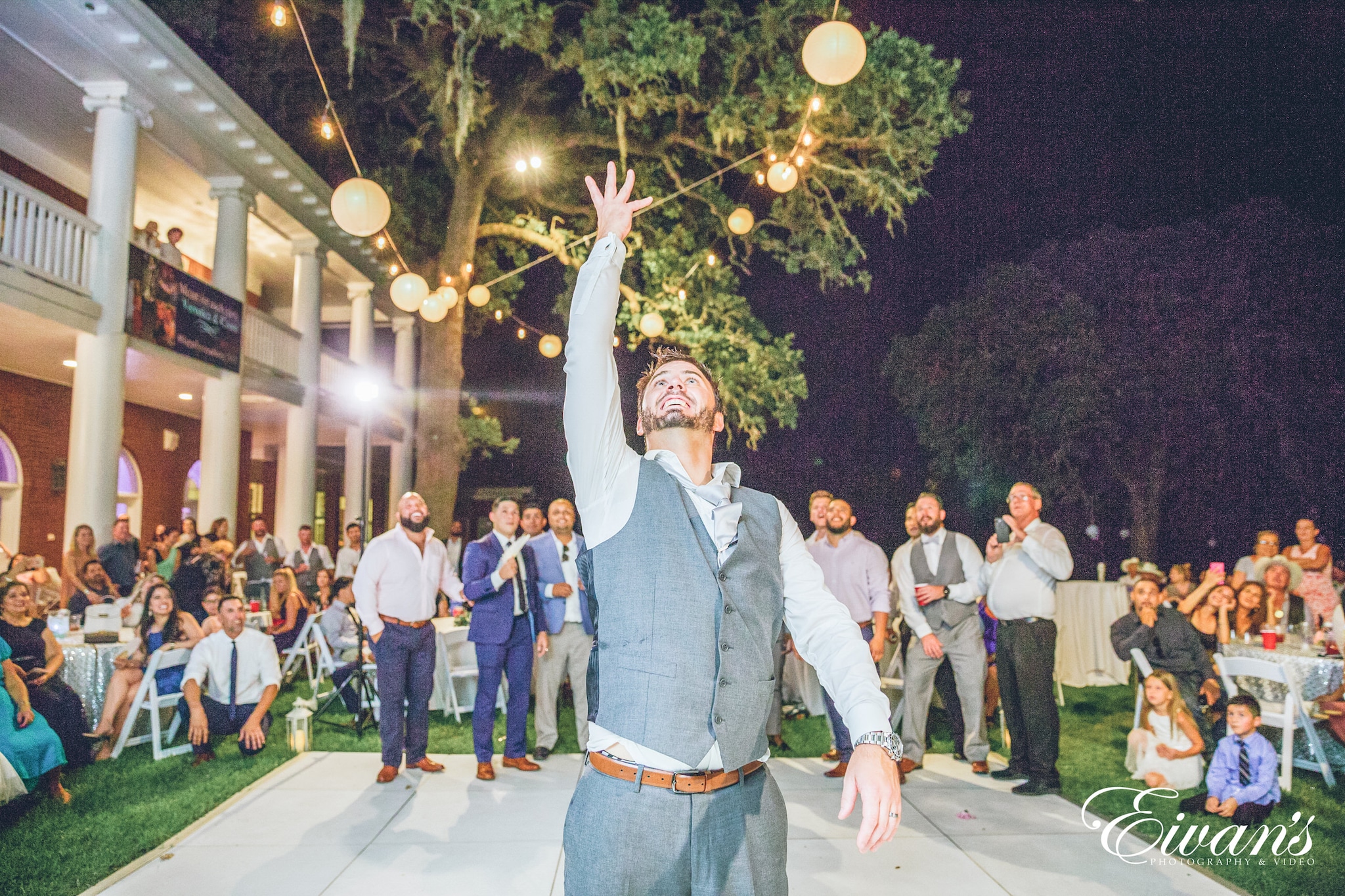 man in gray dress shirt standing on gray concrete floor during nighttime