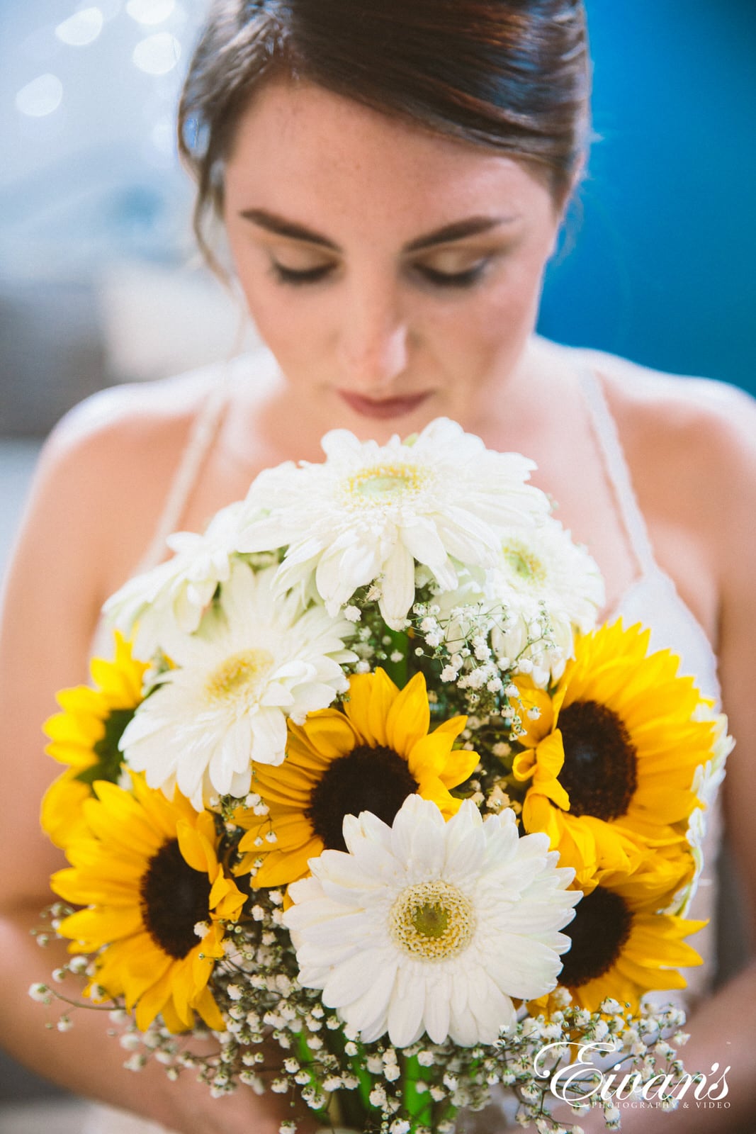 woman in white floral dress holding bouquet of yellow flowers
