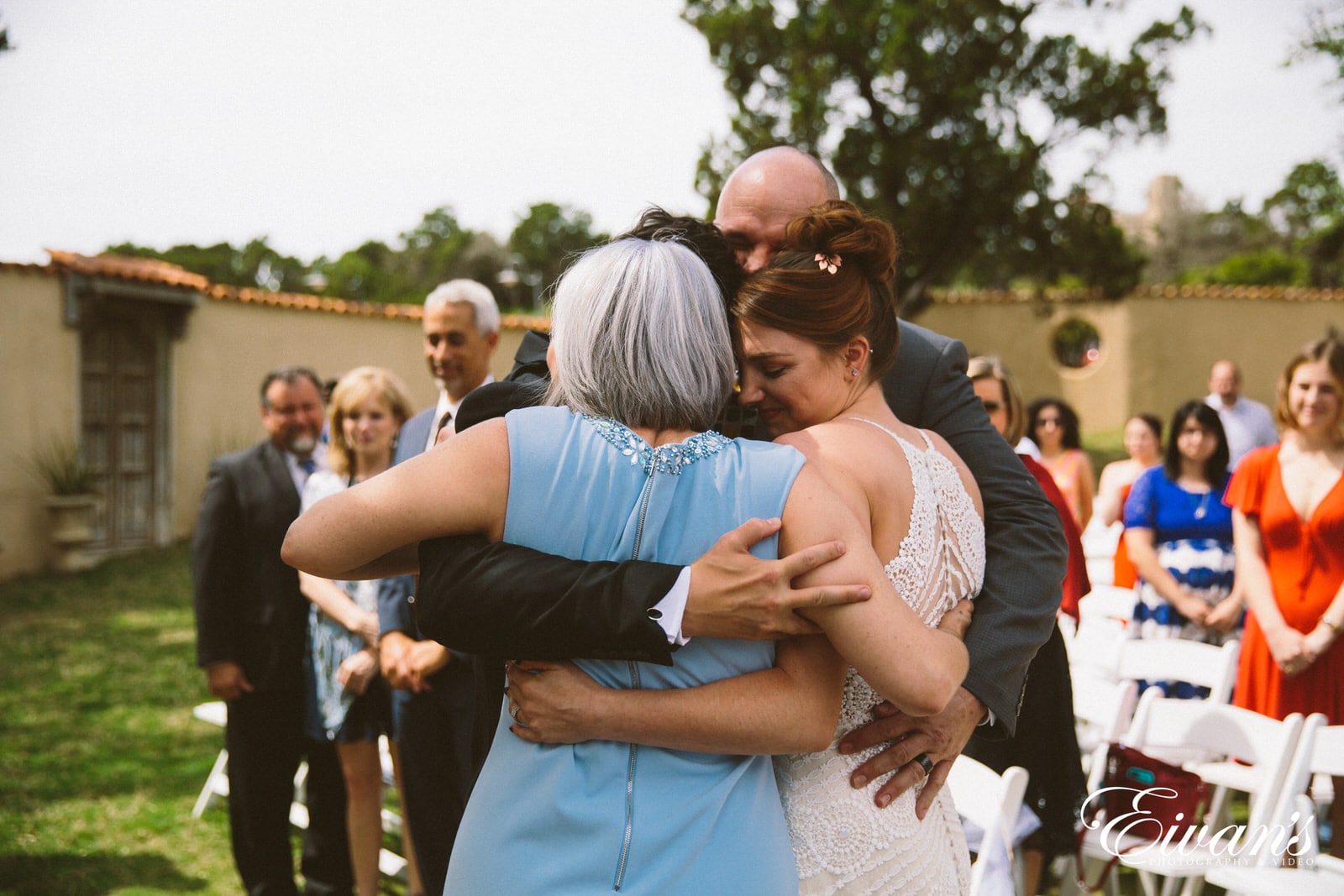 woman in white sleeveless dress hugging woman in black dress