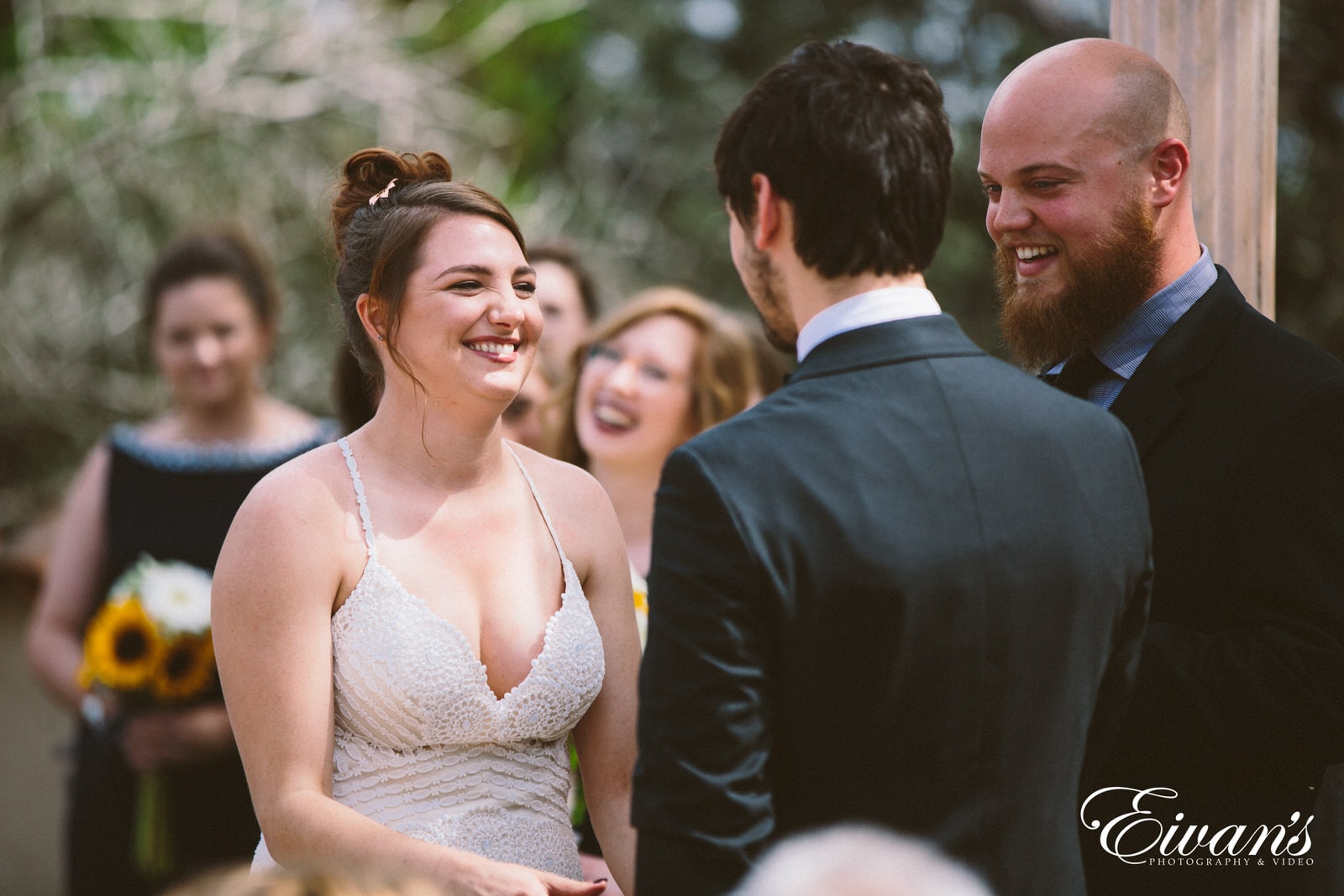 man in black suit jacket kissing woman in white halter top dress