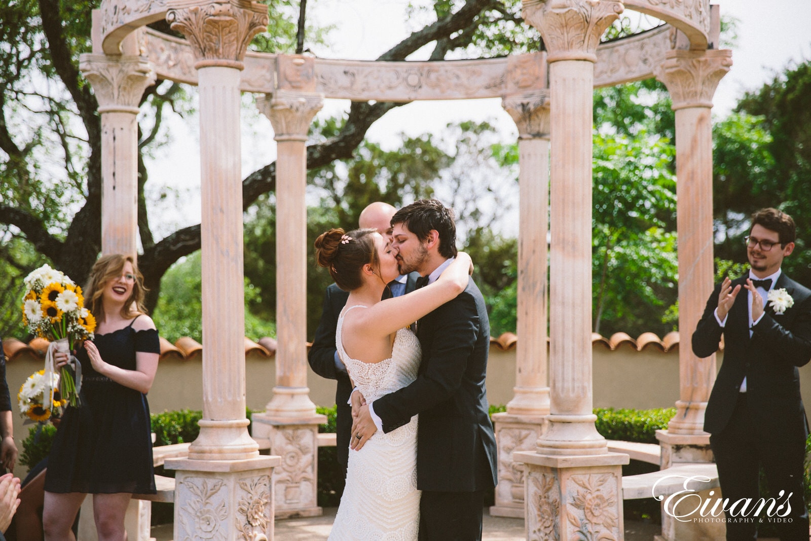 man and woman kissing under arch during daytime