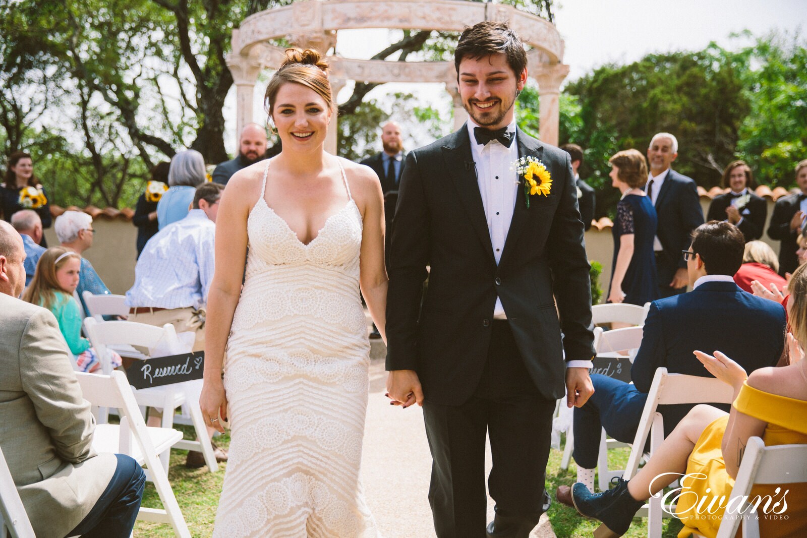 man in black suit standing beside woman in white tube dress