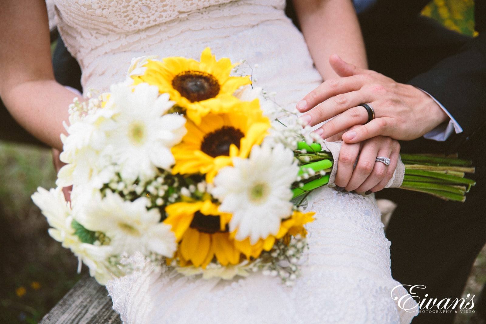 woman in white lace dress holding white and yellow flower bouquet