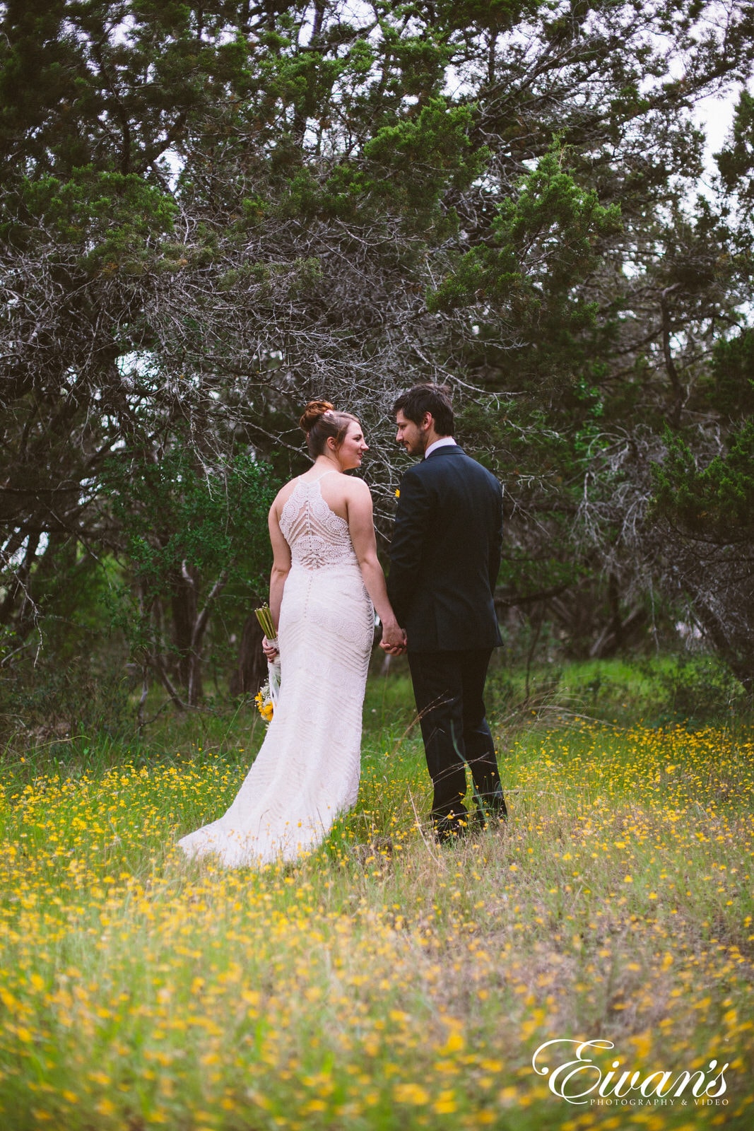 man and woman standing on green grass field surrounded by trees during daytime