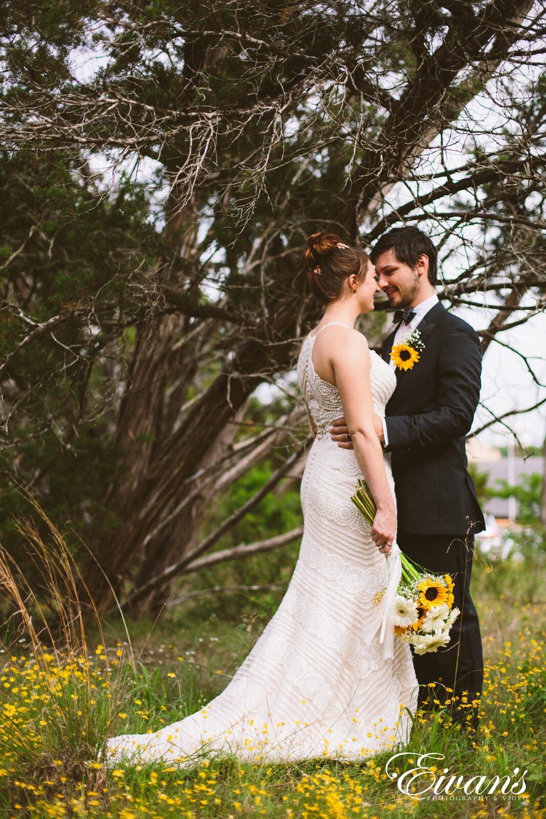 man in black suit kissing woman in white wedding dress