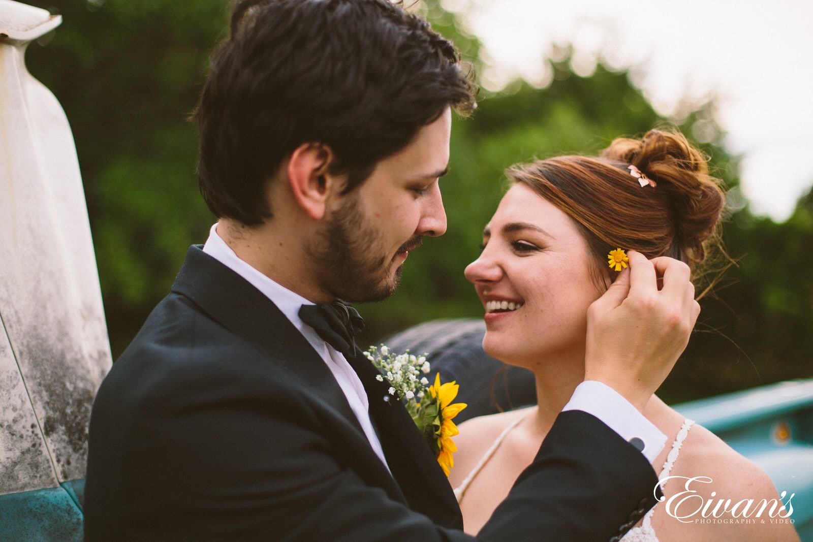 man in black suit kissing woman in yellow floral dress