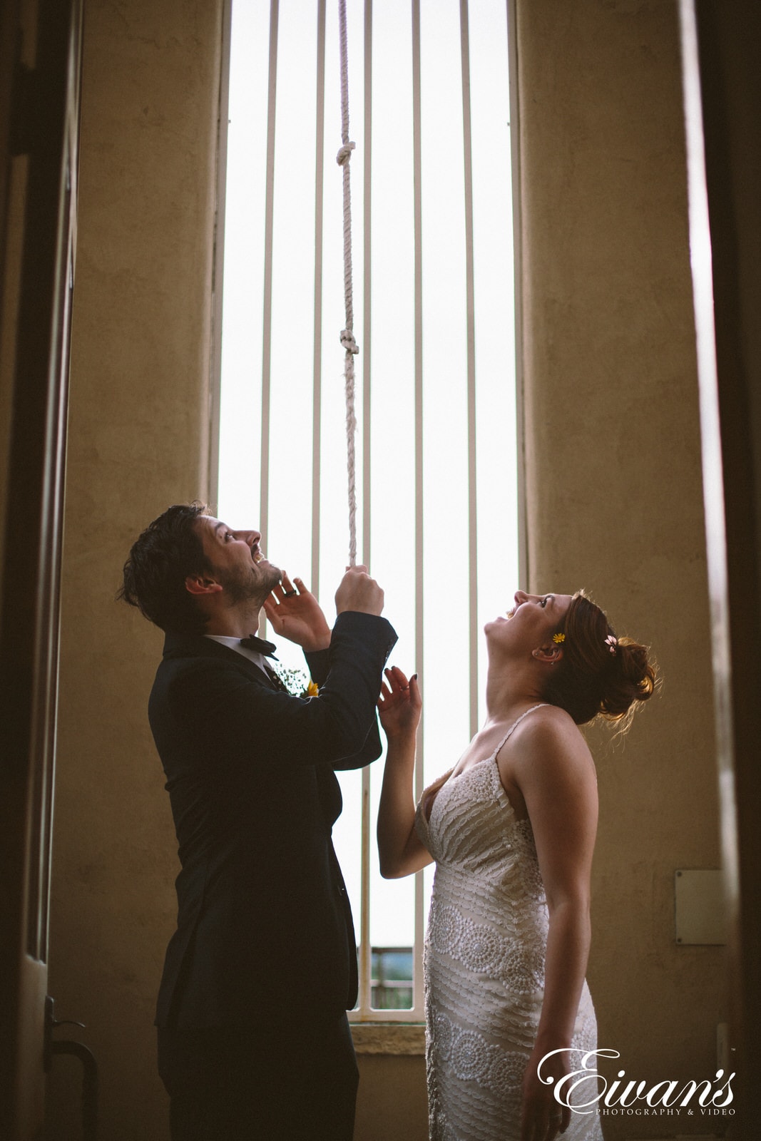 man in black suit kissing woman in white wedding dress