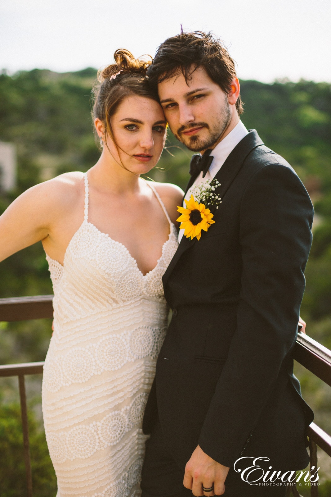 man in black suit jacket hugging woman in white tube dress