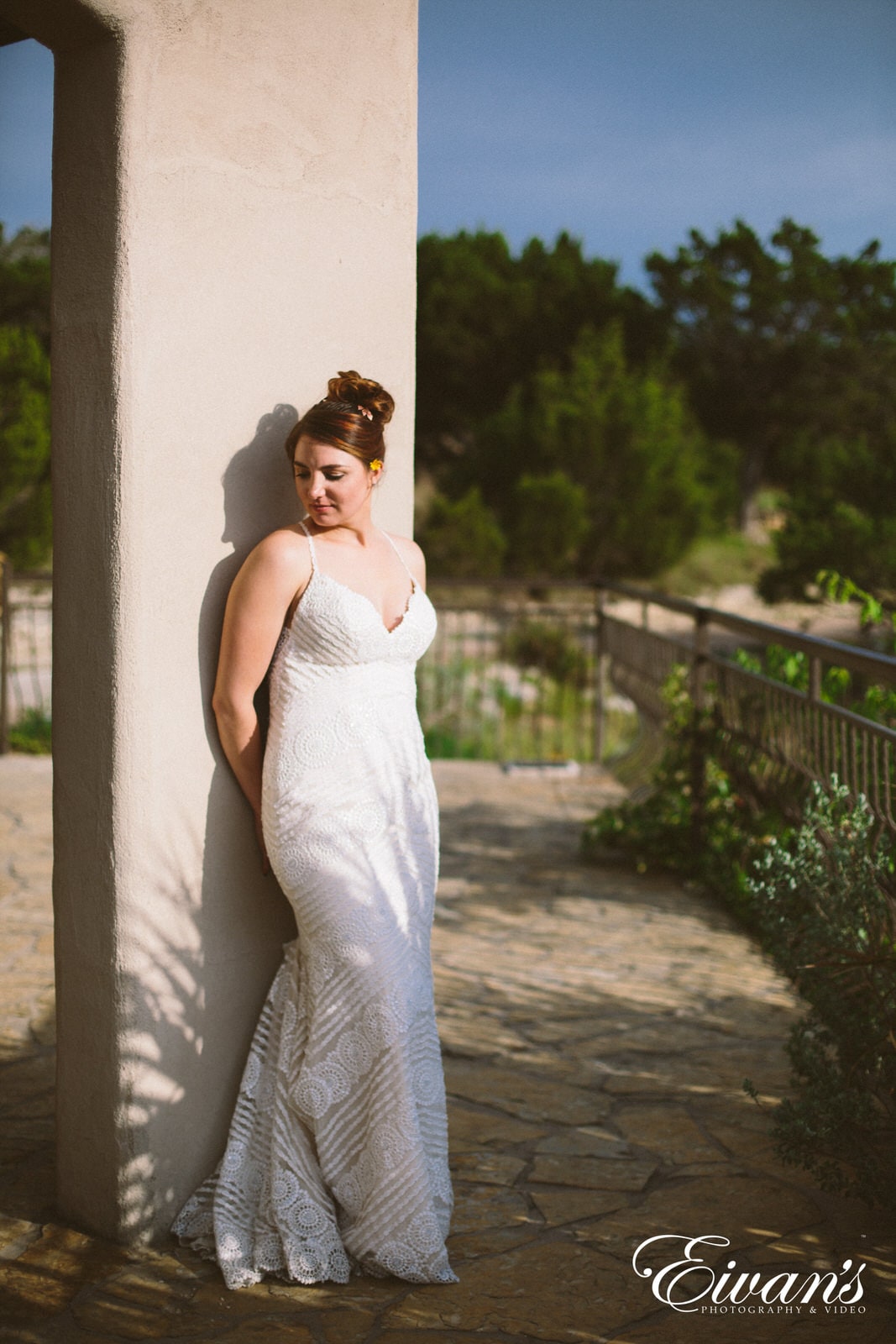 woman in white sleeveless dress leaning on white concrete wall during daytime