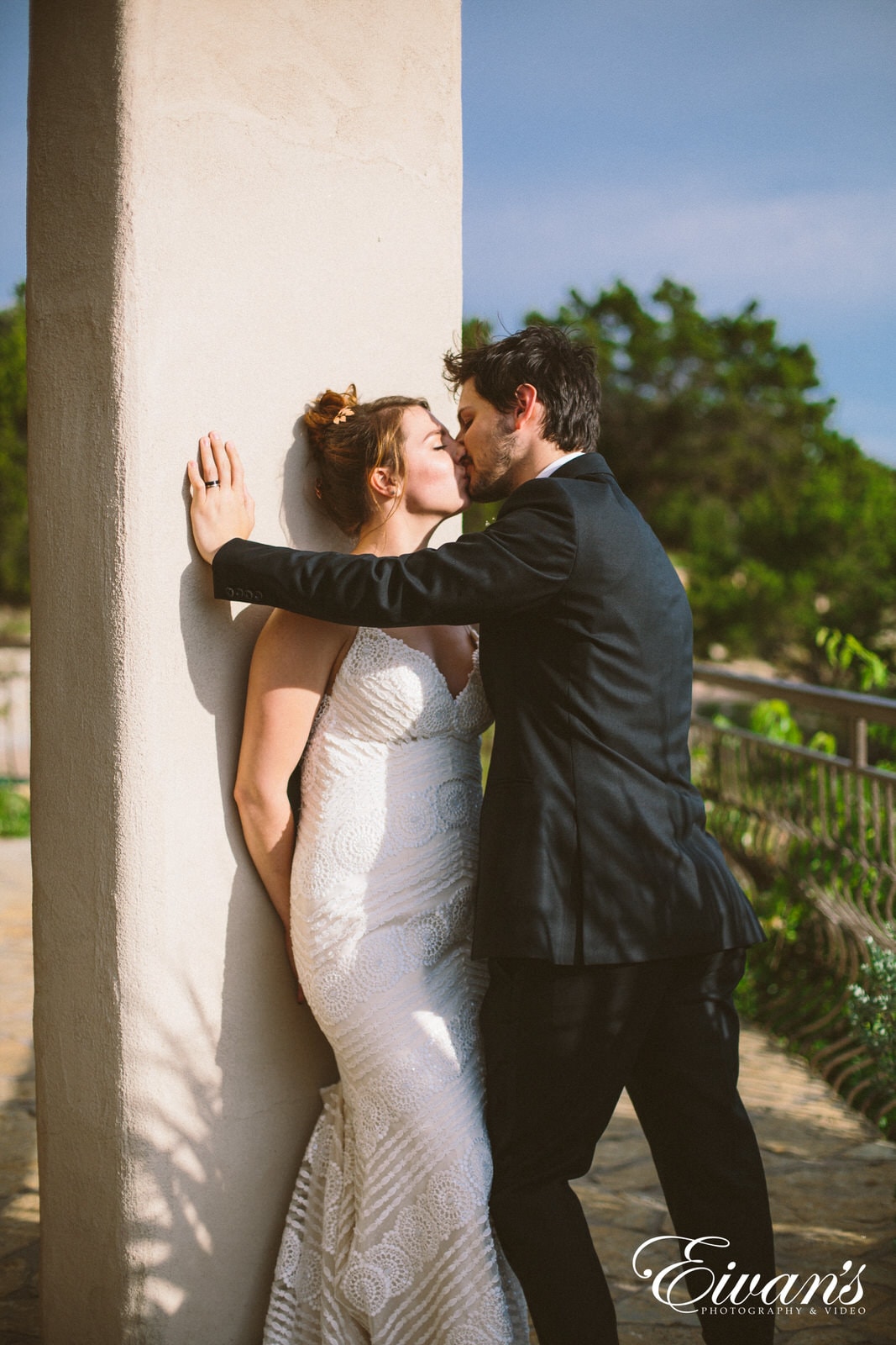 man in black suit kissing woman in white dress