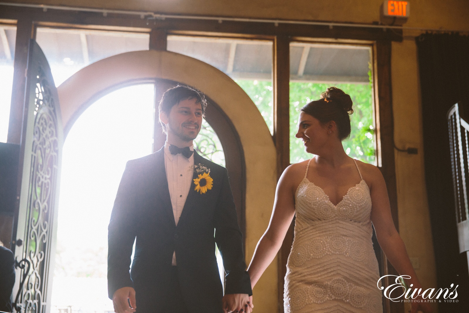 man in black suit standing beside woman in brown sleeveless dress