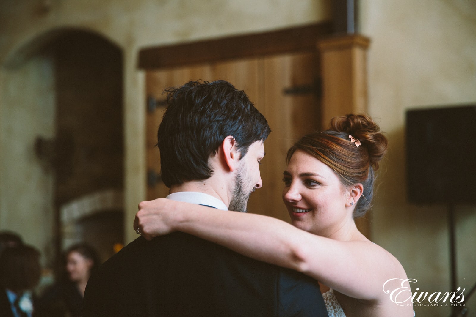 man in black suit kissing woman in white dress