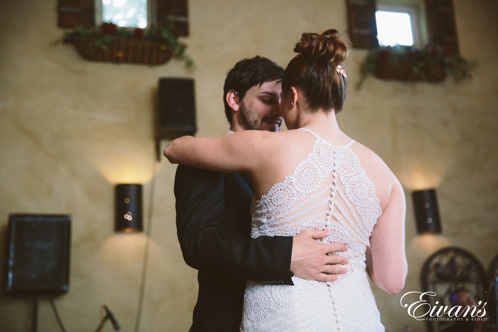 man in black suit kissing woman in white floral dress