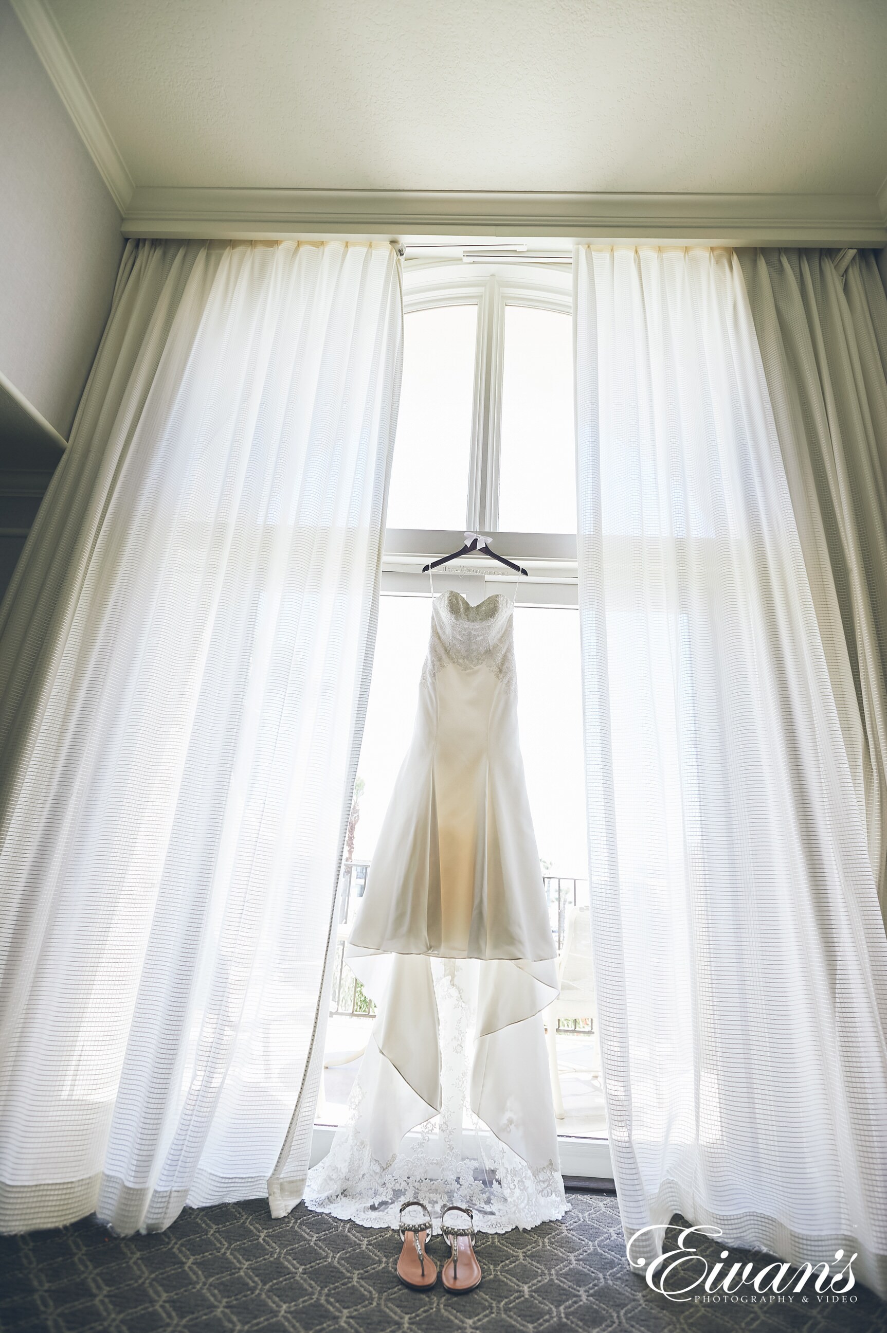 white wedding gown on window