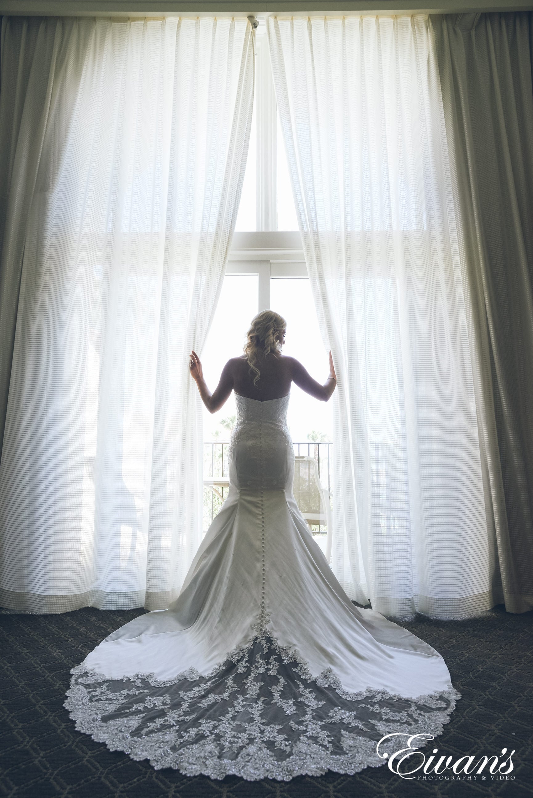 woman in white wedding dress standing on white bed