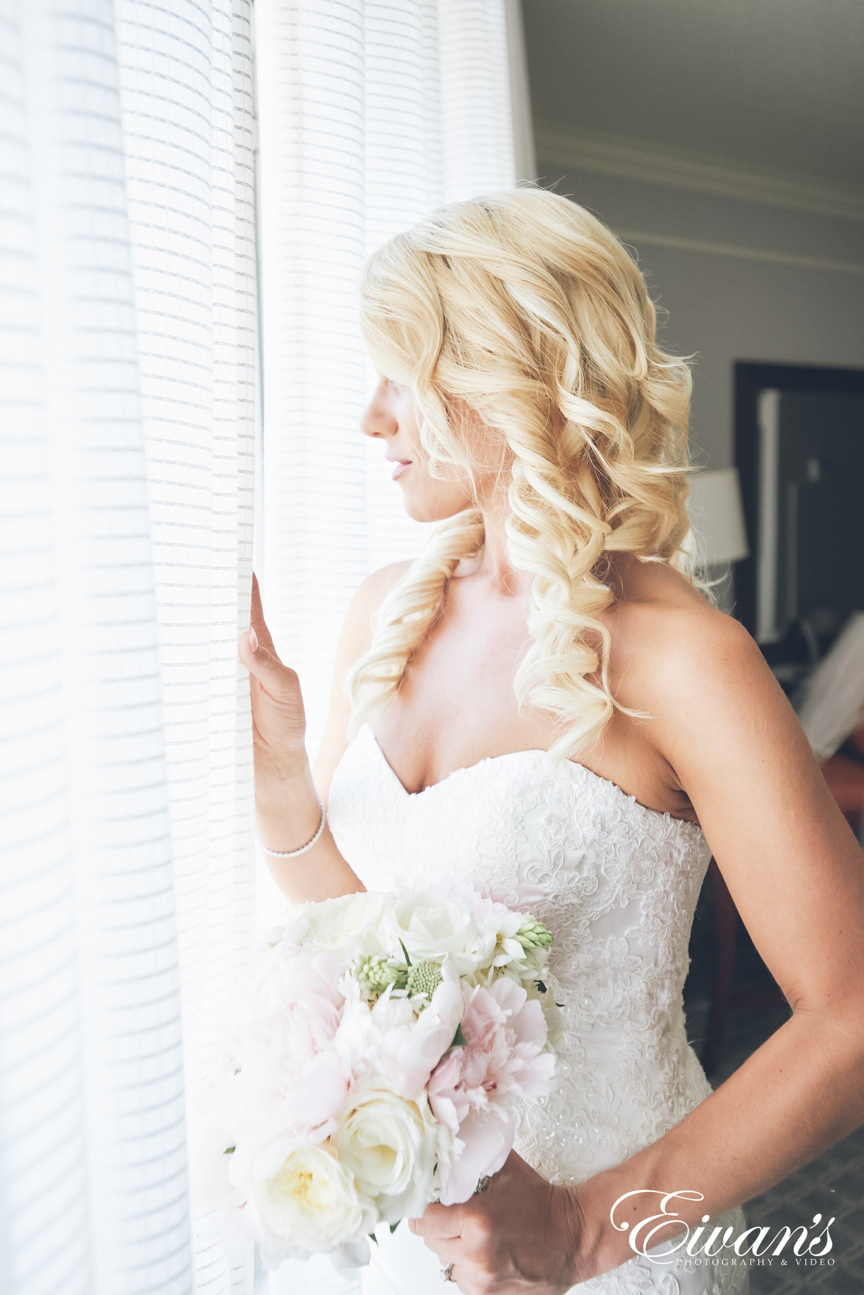 woman in white tube dress holding white flower bouquet