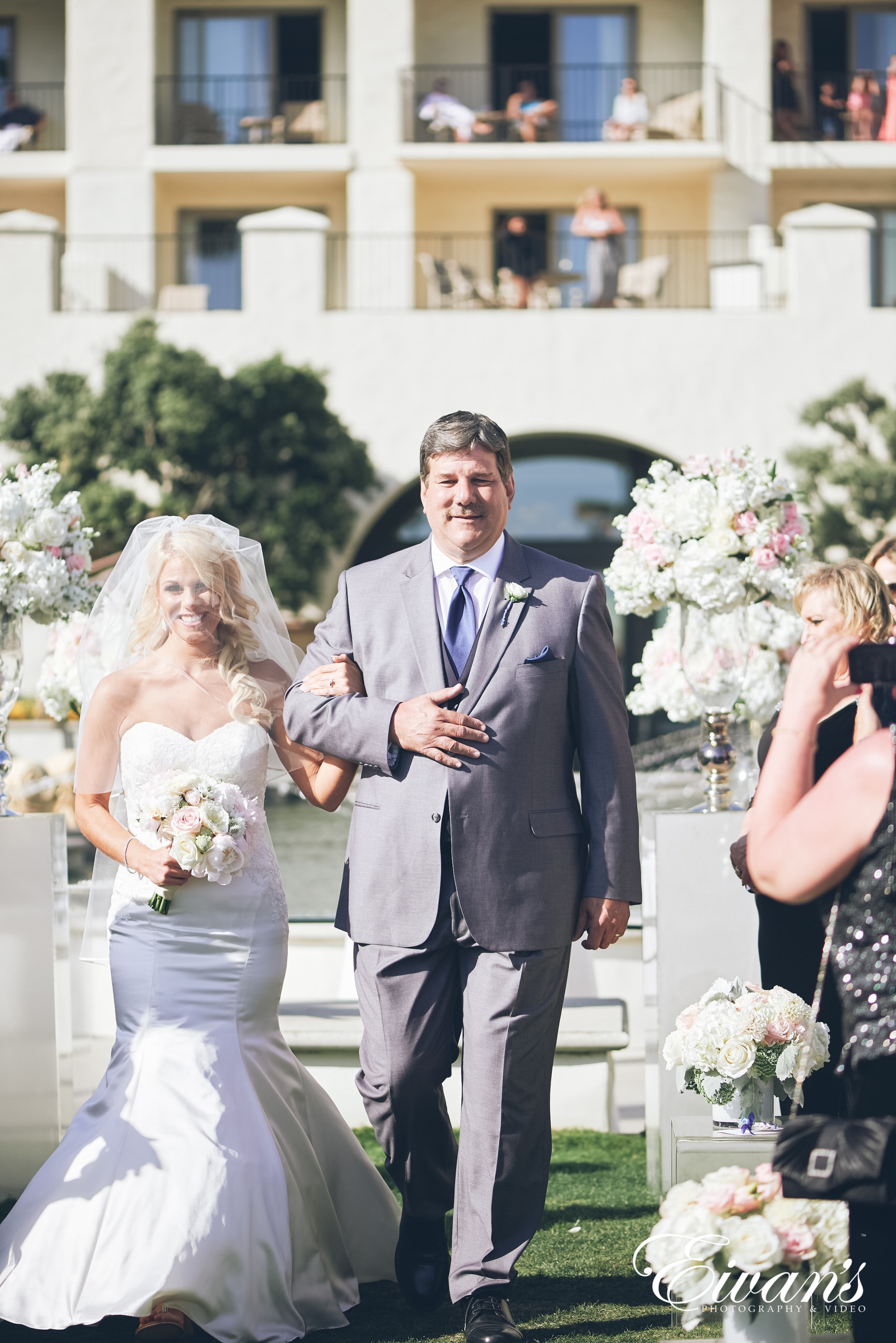 man in black suit holding woman in white wedding dress