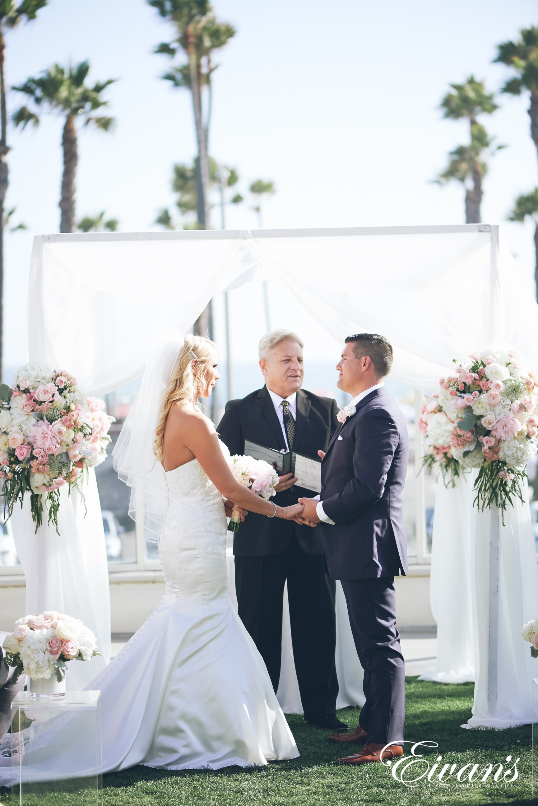 man and woman in a white dress at the alter holding hands