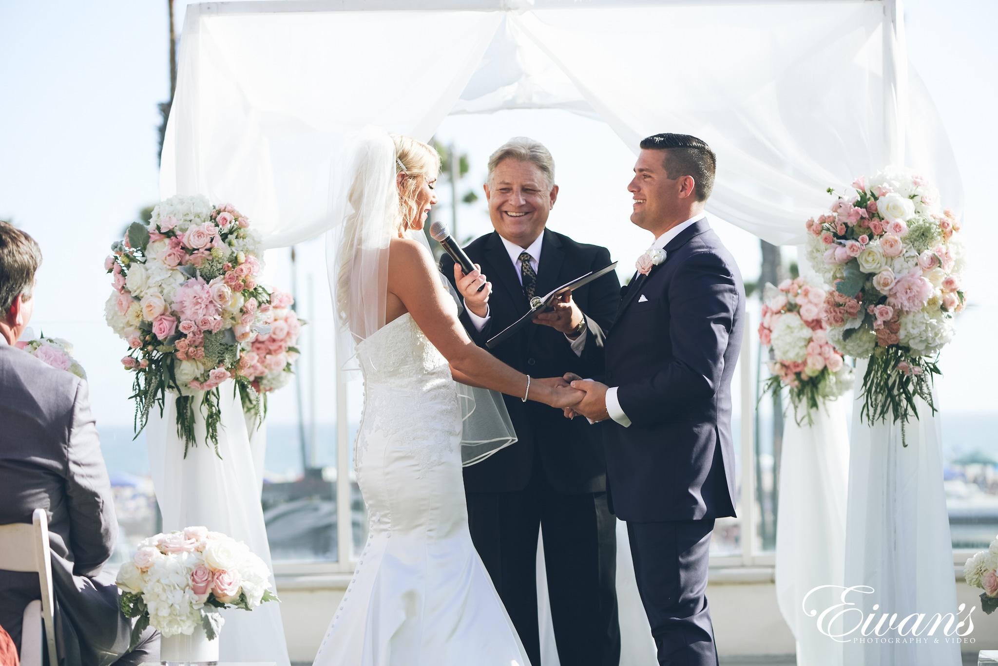 man and woman in a white dress at the alter holding hands