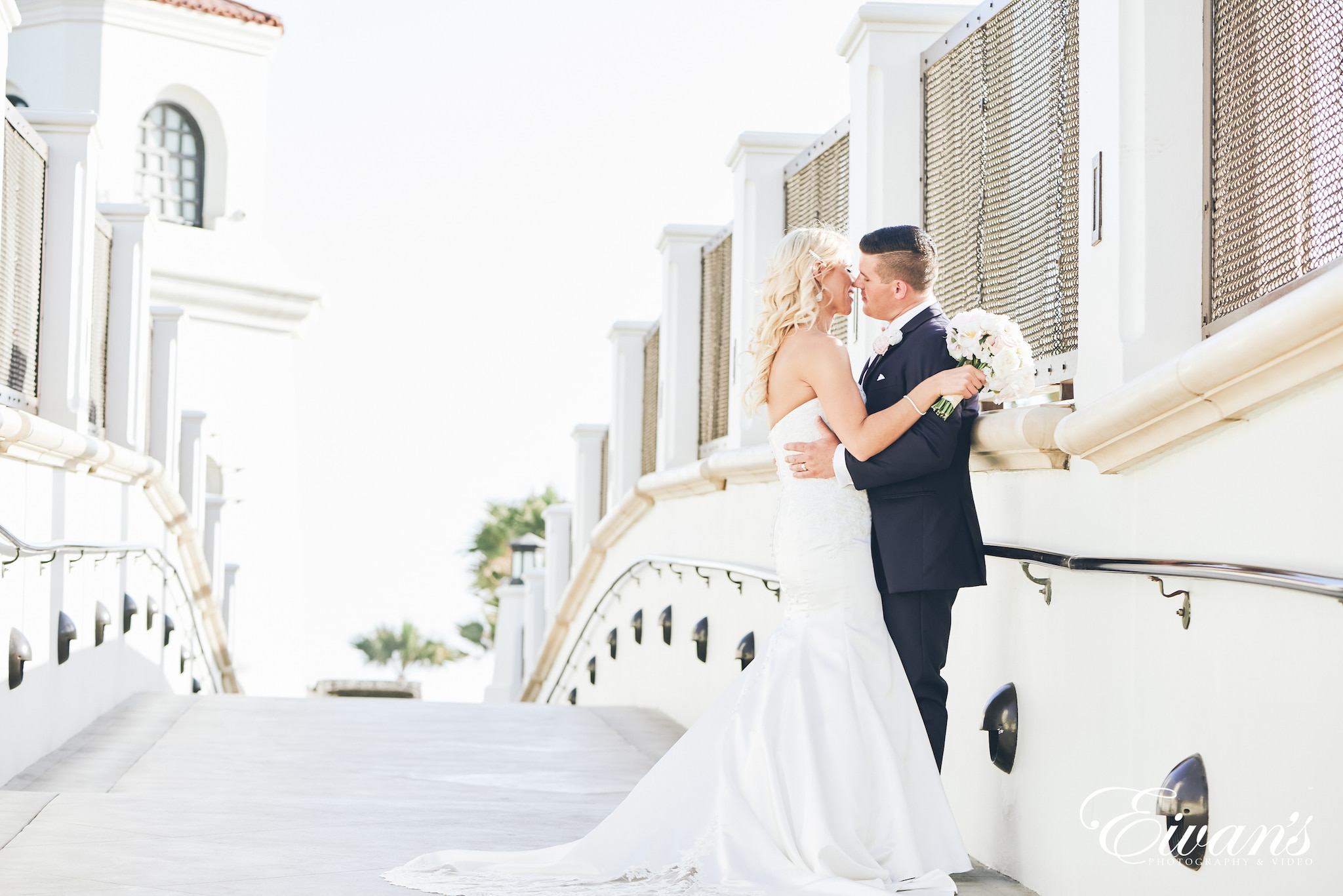 man and woman kissing on a bridge