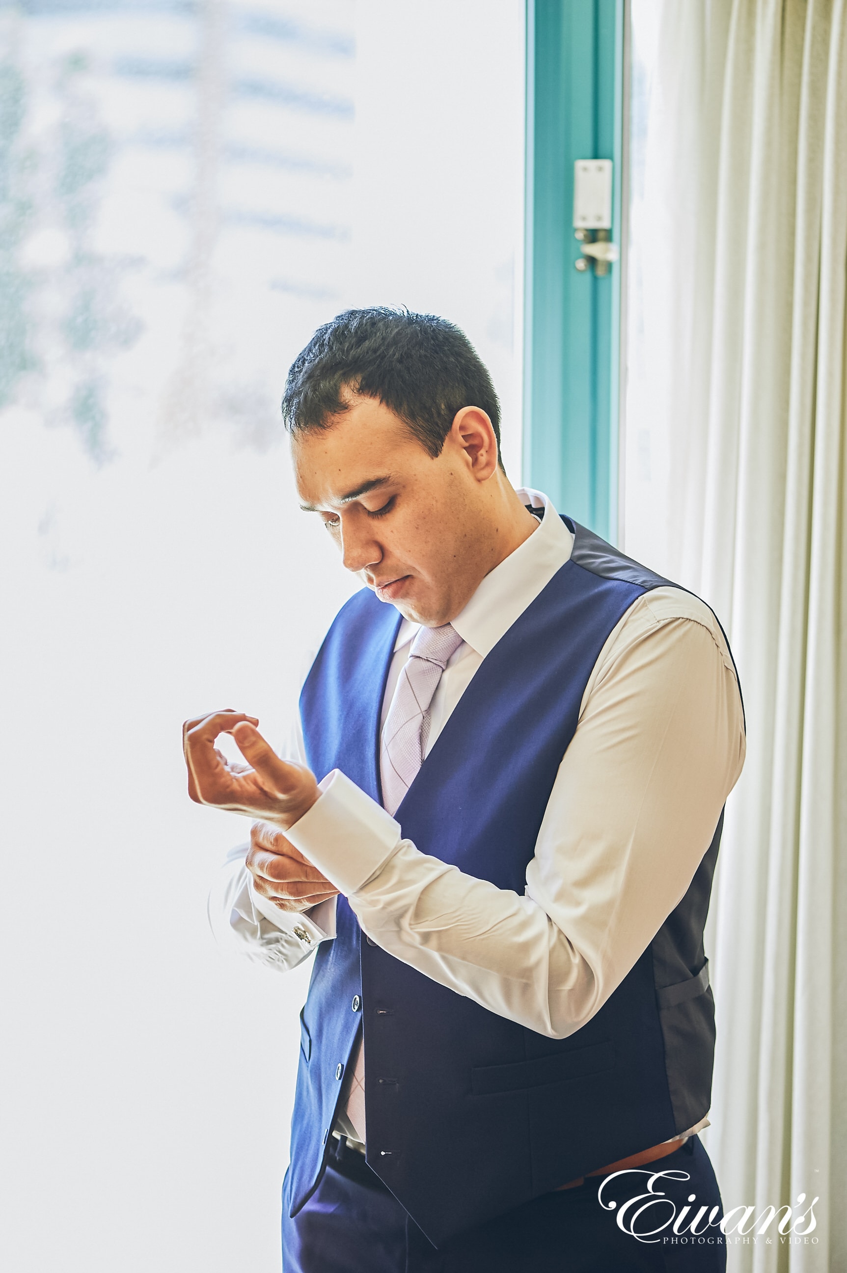 man in a blue vest fixing his sleeve