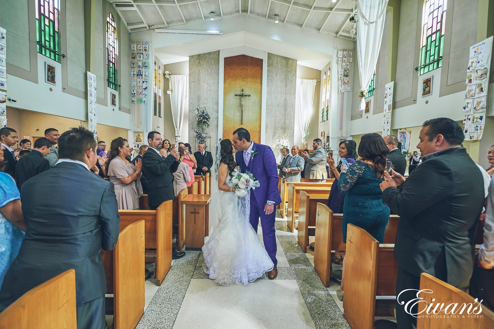 man and woman kissing down the aisle