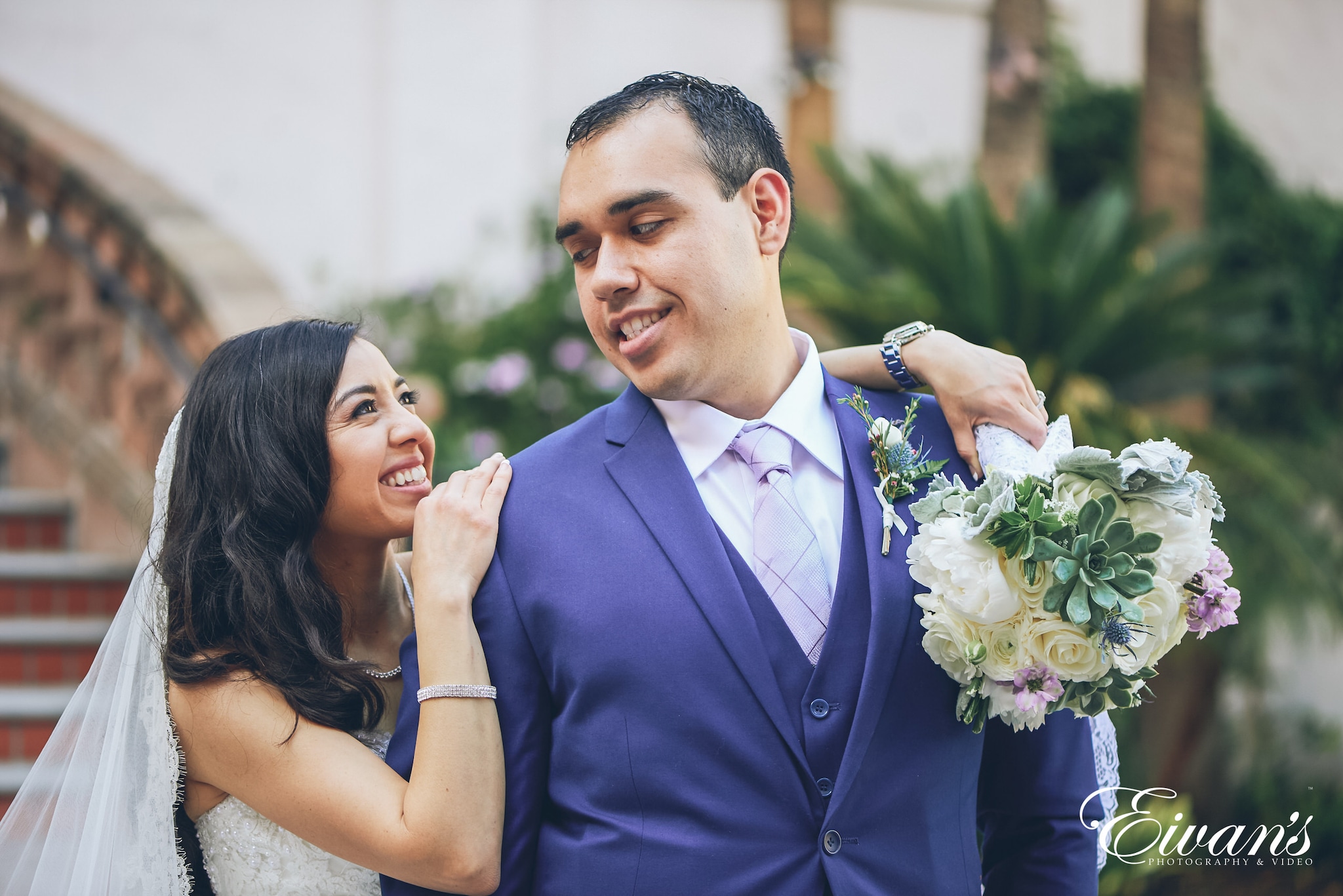 man in blue suit kissing woman in white wedding dress