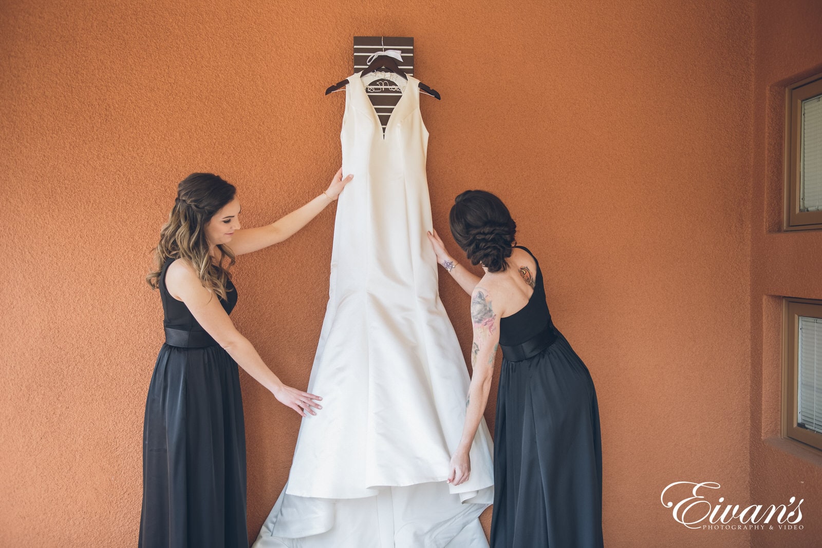 bridesmaids fixing a white wedding dress