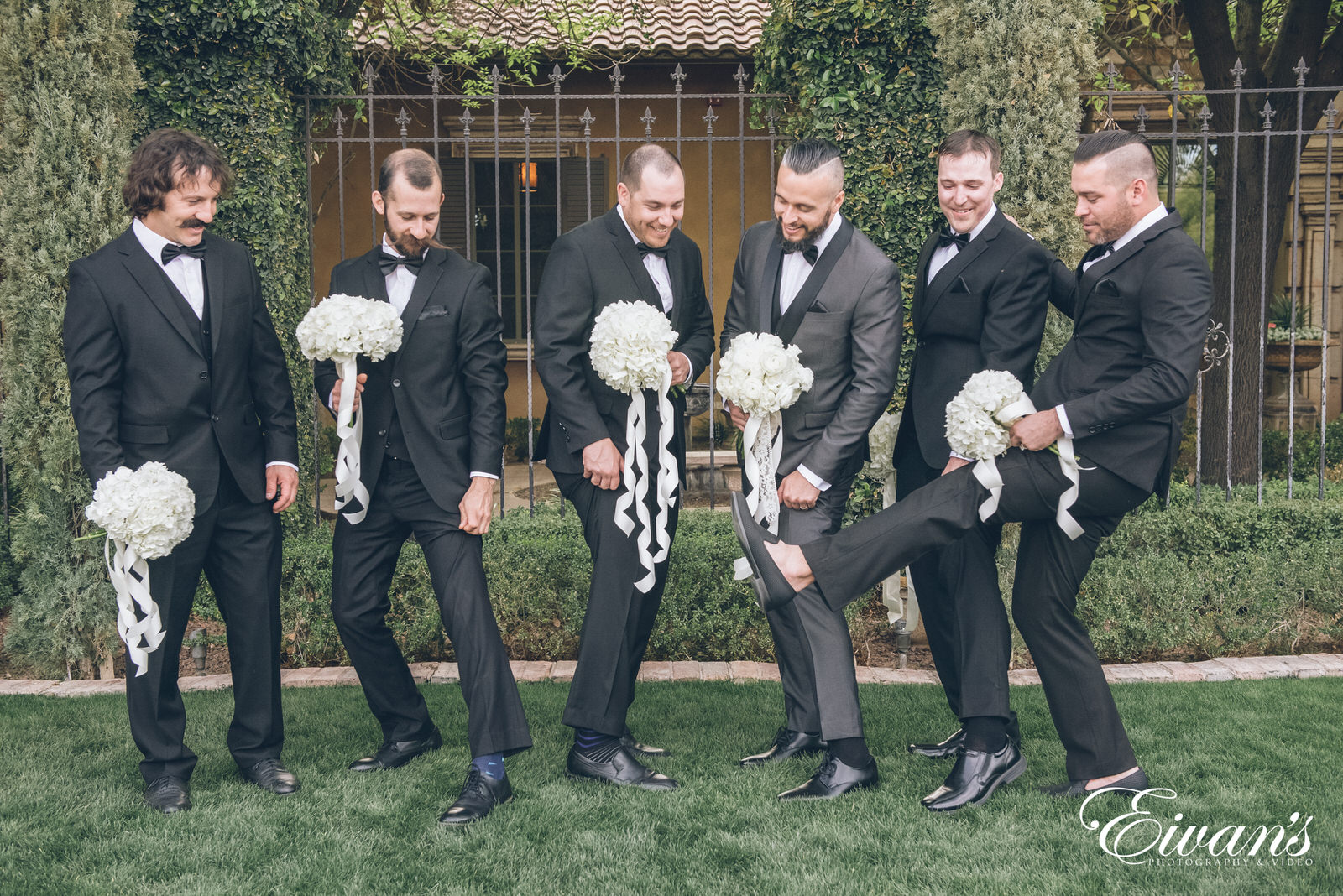 five men posed holding bouquets