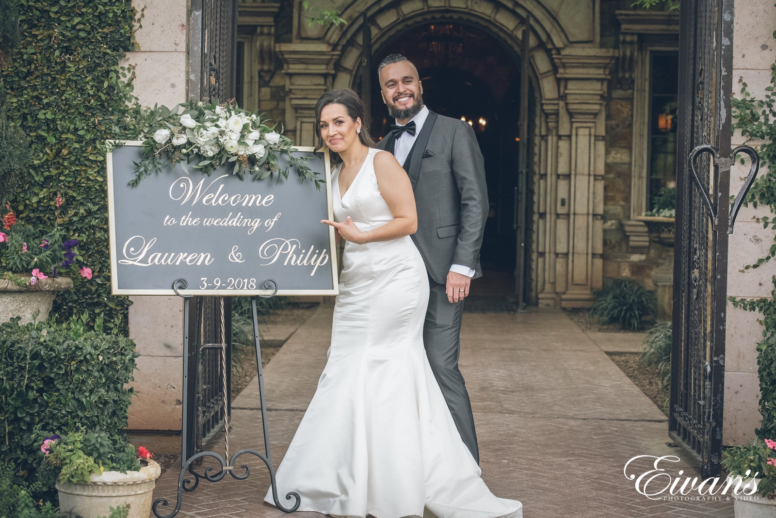 married man and woman standing by their welcome sign