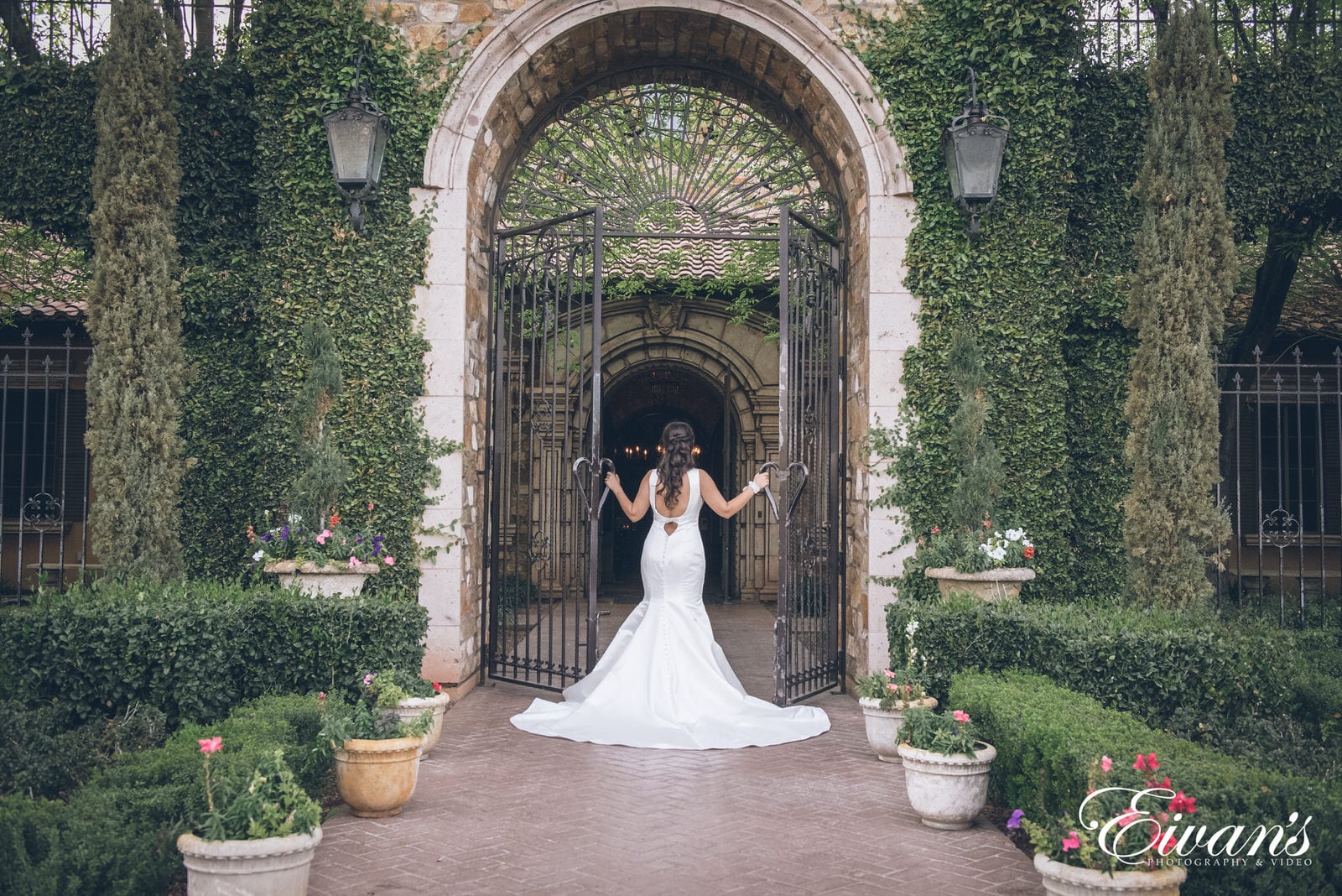 woman in a white dress entering and opening up the gates