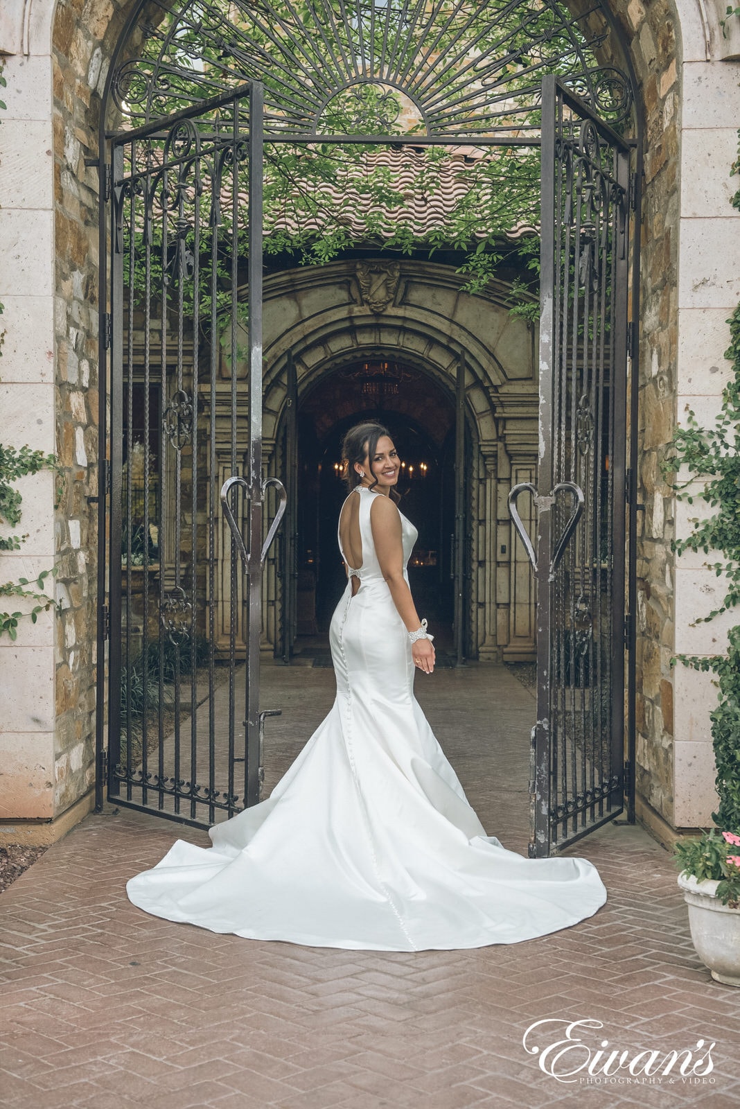 woman in a white dress standing in between open gates