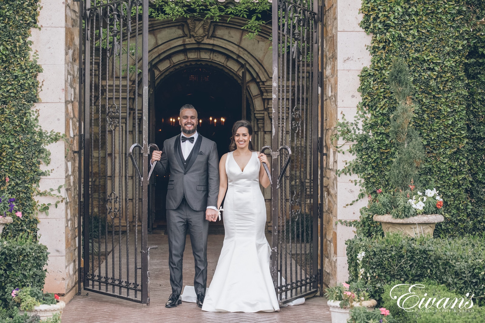 man in black suit and woman in white wedding dress standing in front of brown wooden